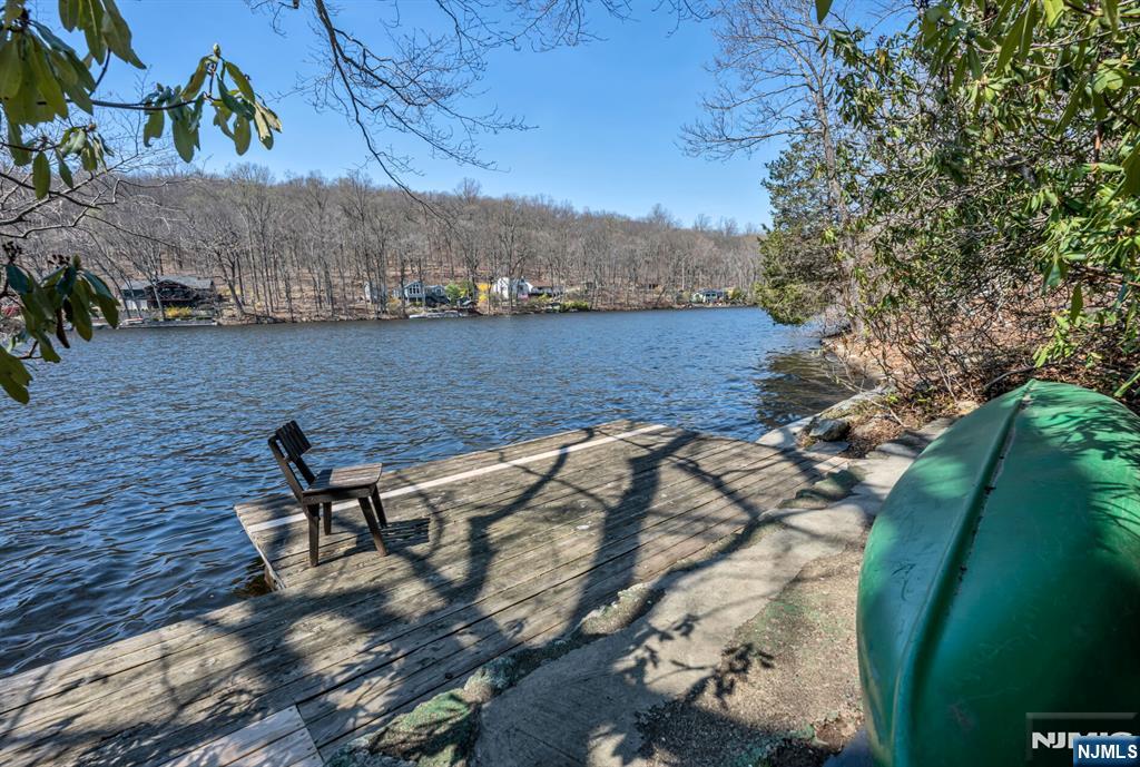 Escape to this idyllic lake front home offering breathtaking lake views and magnificent sunsets. Surrounded by an acre of rustic nature with 200 ft. of lake front and private dock, it offers unusual privacy, beauty, and serenity. The charming house offers a â€œgreat roomâ€ with huge original stone fireplace and 10 ft ceilings, and a 40 ft long glassed-in porch overlooking the lake, perfect for summer and winter quiet enjoyment as well as varied entertaining. It is well suited for artists, writers, musicians or outdoor enthusiasts and uninterrupted remote work. The lake offers swimming, boating (no motors), fishing or just hanging out on the water, and ice skating in winter. It also offers direct access to a variety of wildlife (eagles and blue heron fly over the lake in front of the house). There are numerous private lake hiking trails and public hiking trails in Norvin Green State Park (adjoins lake property) which are easily accessed by foot from the house, and the NYNJ Trail Conference offers trail networks within easy drives. The lake community is open and inclusive to those interested but also respectful of those who prefer their own company. This idyllic property offers a rare combination of seclusion and accessibility and is ideal for Weekend and Summer Getaways or Year-Round Living, with Rt. 287 only 1.5 miles away and Manhattan only 25 miles away.
