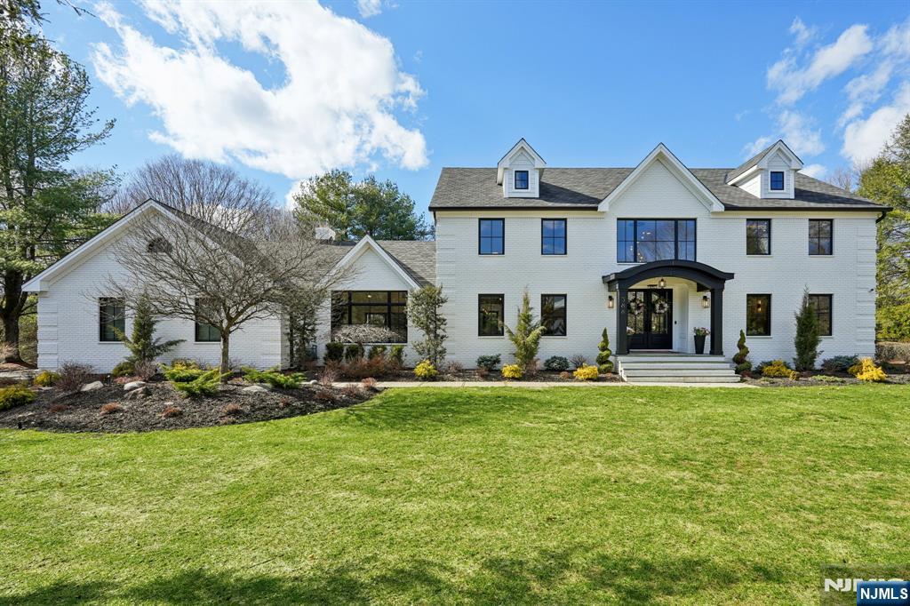Fully redesigned and rebuilt in January 2025, this custom home offers modern luxury. A two-story foyer, a dramatic family room with a cathedral ceiling and oversized windows bringing in light. Gas or wood burning fireplace creates a warm focal point. Nine-foot ceilings continue on the second level. 5 bedrooms, 5 full baths, office, living room, dining room, and a three-car garage. Porcelain tiles from Porcelanosa highlights the main areas, while European white oak flooring enhances bedrooms and living spaces. A prestigious kitchen by Kuche + Cucina features porcelain countertops by Neolit and a professional-grade appliance suite by Dacor. A first-floor bath includes a custom floating vanity in Himalayan Cristal stone. The primary suite offers a spa-style bath with oversized shower, Victoria + Albert designer soaking tub, custom vanity by Kuche + Cucina, and custom double sinks. Additional bathrooms feature imported European tile and upscale finishes. The finished lower level includes a large open area with tile flooring, playroom, bar with quartzite countertop, full bath, gym, storage, and a custom 8 person sauna. Addition, Spray foam insulation, new septic, tankless water heaters, and an ERV system providing fresh air. Modern trim and upscale finishes. Set on a private 0.92-acre lot surrounded by mature trees. The backyard features a brand-new patio deck, covered lounge, gas fire pit, summer kitchen, rich landscaping, and gated yard. Seller is a Real Estate Agent.