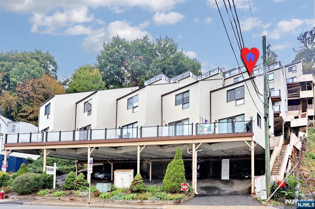 Welcome to Edgehill's 1st level end unit two-bedroom that offers beautiful Hudson River and NYC views. The location is highly desirable, situated directly across the street from Edgewater's Veterans Field. The 1st level features a modern, updated kitchen complete with granite counters and a dining area. This floor also houses a large living room with access to a deck, as well as an updated powder room. Moving to the upper level, the spacious master bedroom is a highlight, boasting custom closets and high ceilings This floor also includes a full bathroom, a second bedroom with custom closets, laundry facilities, and easy access to a large attic for storage. Renovations and upgrades completed in 2023 include new kitchen, appliances, bathroom vanities, washer and dryer and HVAC. Additional benefits include hardwood floors throughout, low HOA fees one covered parking space.and exceptional commuter access, with an express bus stop right in front of the building. It is also conveniently located near schools, shops, parks, the ferry, and public transportation.