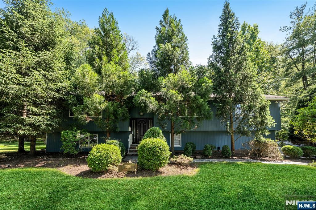 Rare opportunity in sought-after Haworth! This 5200 sq. ft. expanded bi-level offers exceptional space and pride of ownership throughout. The home features a gourmet eat-in kitchen which boasts granite countertops, stainless steel appliances, and opens to a covered outdoor terrace with built-in barbecue overlooking the heated gunite pool and expansive patio. The Banquet size dining room is ideal for hosting large gatherings. Retreat to the luxurious primary suite with skylights, walls of windows overlooking serene woodlands, sitting area with fireplace, spa-like marble bath with soaking tub, oversized shower, double vanity, and Toto bidet. Three additional spacious bedrooms, two full baths, and a conveniently located laundry room complete the bedroom level. The ground level features a fifth bedroom, full bath, and an oversized recreation room with fireplace and walkout access to the private backyard oasis featuring a heated pool w/ jacuzzi , fire pit area, and private wooded setting. A standout feature is the full apartment with private entrance, offering an open floor plan consisting of kitchen, living room with fireplace, dining area, bedroom, full bath, and direct access to the rear yard. Ideal for extended family or multi-generational living. Additional highlights include an oversized two-car garage with workshop area, second laundry room, storage galore, newer roof, and full-house generator. Close to fine dining, shopping malls and NYC. This home is a must see!