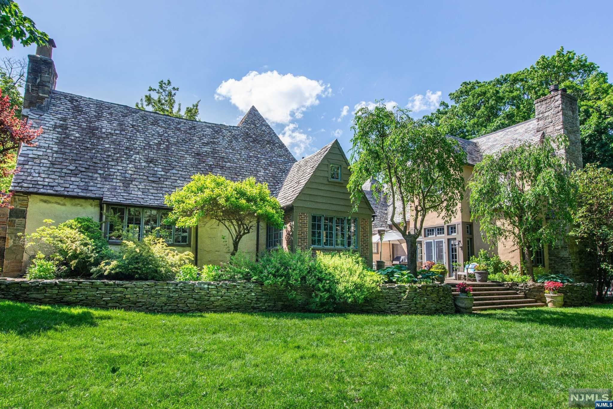 Magnificent Cotswold Arts & Crafts Tudor on 2/3 acre in Estate Section, seamlessly expanded in 2011. 6 BRs, 5.1 bths, luxurious primary suite, gourmet EIK, sauna, heated inground pool, herb garden, 2-car attached garage, circular drive, wide-plank floors, beamed ceilings, expansive grounds. LR w Juliet balcony. Formal DR w access to patio. Sitting rm w builtins. Full bath w double sinks & BR w FP. EIK open to courtyard & garden, 2 center islands, custom cabs, SS appls, stone counters, workstation, dining area & garage access. Mudrm, laundry rm, PR, closet, basement access, private parking w garage entry. Fam rm w gas FP, beamed ceiling, wood panels, doors to pool & courtyard. 2-story staircase to expansive 2nd fl w 5 BRs, each w ensuite bth. Spa-like primary suite w vaulted ceilings, WB FP, 2 walkin closets w builtins; Balcony over pool. Ensuite bath w stone fl, walkin shower, tub, 2 vanity sinks, laundry chute. Fin bmnt w media rm, gym, rec rm, sauna, storage. Near everything!