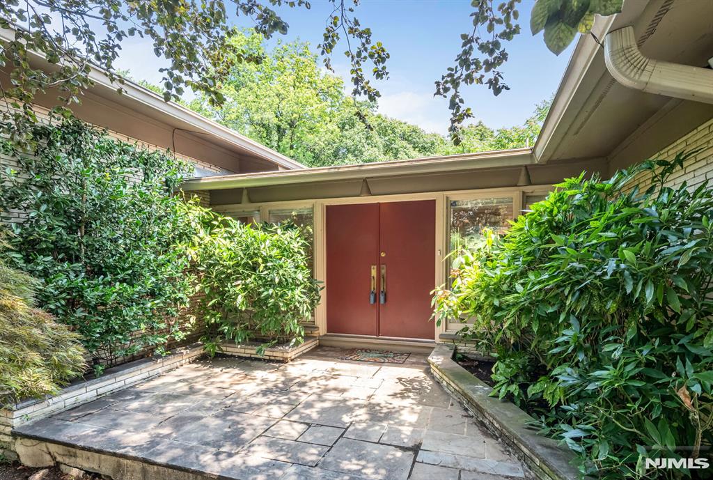 Opportunity awaits! Set on a generous .7-acre lot with views of the NYC skyline, this expansive mid-century modern split ranch offers endless potential for investors, builders or end-users with a vision. Featuring large scale rooms and a versatile layout, the home includes a formal living room, dining room and eat-in kitchen, family room with access to upper patio all on the main level. A few steps down offers private office, full bath and oversized laundry room. Another few steps down leads to a spacious game roomâ€“ perfect for future entertaining or flexible living. Upstairs youâ€™ll find find large bedrooms including a primary suite. Additional highlights include a 3- car garage, baseboard heating & central AC. While the home needs updating, the size, setting and location make it an incredible value-add opportunity. Home is being sold strictly â€œas isâ€. Donâ€™t miss the chance to bring this diamond in the rough to life.