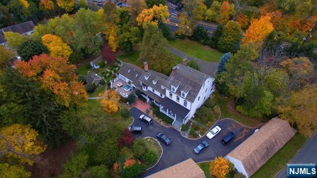 Set on approximately two acres in a prominent Paramus location, this expanded historic Colonial offers exceptional space, character, and opportunity. The home features 15 rooms, including five bedrooms, two primary suites, five full baths, and one half bath. Gracious living areas include a formal living room with fireplace, banquet sized dining room with fireplace, and a spacious gathering room with fireplace and French doors leading to the deck. The large kitchen offers generous space and flexibility for future updating. Additional features include a partially finished basement with exterior access, a circular driveway with access from both Century Road and Paramus Road, an in ground pool (AS IS), four stall carriage house, and four oversized detached garage bays with high ceilings and storage. New roof. Property is being sold strictly as is. A rare opportunity to restore, renovate, or reimagine a distinctive historic Paramus property with substantial land and unique architectural presence.