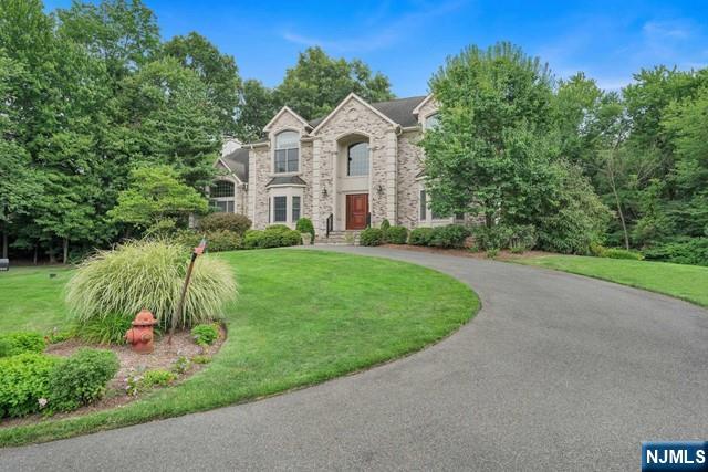 Stunning colonial nestled on cul-de-sac with 1 acre of property. This home features spacious foyer, large formal dining room, updated chefs kitchen, great room with fireplace, guest room with full bathroom, laundry and formal living room on first floor. The second floor includes 4 bedrooms and 3 full bathrooms including primary suite with luxury bathroom, walk in closet and sitting room with fireplace. Not to be missed is the added living space in basement which includes recreation area, and home gym. The backyard is unique setting on 1 acre of private lush property complete with covered deck, paver patio and built in BBQ. Home has a whole house generator, invisible fence and water softener. One of the best features of this location is it's proximity to NYC transportation, schools, and downtown shops and restaurants just steps away.