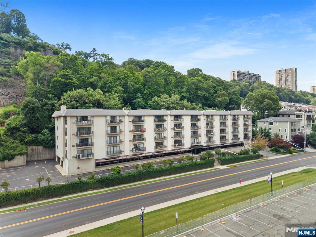 Spacious 1,452 sq. ft. (approximate) waterfront condominium offering breathtaking, unobstructed Hudson River and NYC skyline views. Beautifully maintained and thoughtfully refreshed, this 2-bedroom, 2-bath residence combines generous living space, spectacular scenery, and outstanding value in one of Edgewater's most desirable locations. Freshly painted and updated with new luxury vinyl plank flooring, trim, ceilings, and modern lighting, the home offers a clean, move-in-ready feel while providing the opportunity to personalize cosmetic finishes over time. The expansive layout features bright living and dining areas, abundant closet space, in-unit laundry, and an oversized primary suite with en suite bath. Step onto your private balcony and enjoy panoramic river views, stunning sunsets, and the iconic Manhattan skyline. Residents enjoy the convenience of a full-service elevator building with a doorman, fitness center, community room, assigned parking, and central air. Ideally located along River Road, you're just moments from premier shopping, waterfront dining, parks, and convenient transportation to New York City. Offering exceptional space, incredible views, and outstanding potential, this is a rare opportunity to own a waterfront home you can truly make your own.