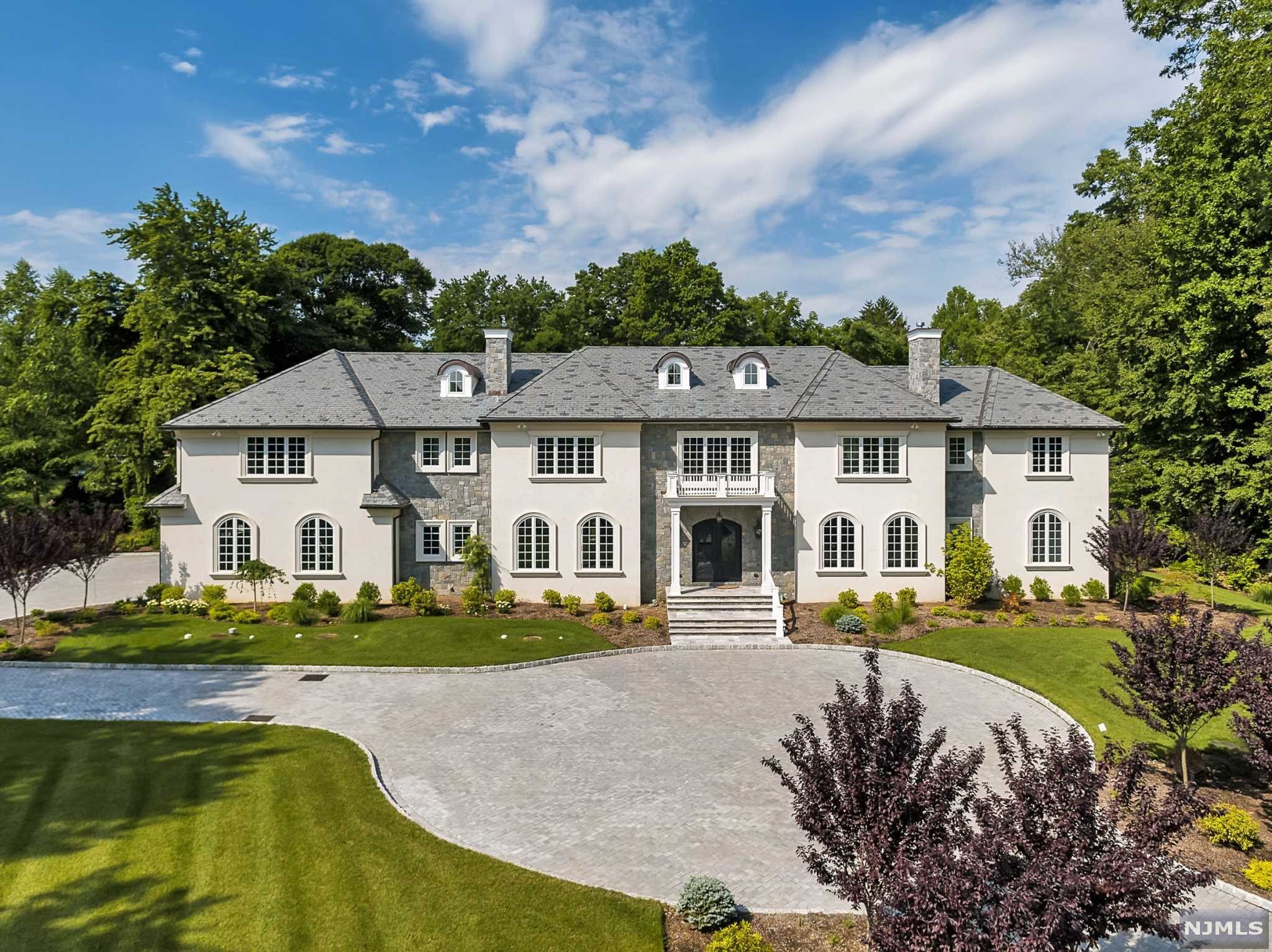 2016 grand modern classic estate by one of the area's premier builders, was chosen for 2016 Designer Showhouse For Heroes to Heroes. (Photos from the Showhouse). Magnificent residence set on 2+ flat acres, at the end of a prime Chestnut Ridge double cul-de-sac, this stone and stucco home has it all! Real slate roof, state of the art Kuche-Cucina kitchen and cabinetry throughout the house, 6 bedrooms, including 2 primary bedroom suites (one on the 1st floor) all with ensuite bathrooms and walk-in closets. A smart home,radiant and hydronic heating combination, 4 car garage, generator and elevator. A beautiful B&B salt water heated pool and a cabana, surrounded by professionally designed landscape. 9,000+ sq.ft. plus a full height, unfinished basement. Plans for a finished basement are available. Owner has NJRE license.