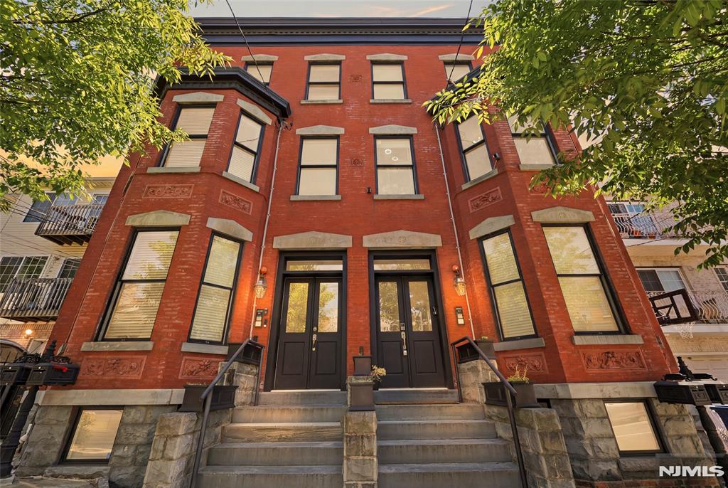 Experience timeless elegance blended with modern luxury in this beautifully restored Newark brownstone, conveniently located near NJ Transit Broad Street Station and the Riverfront Stadium Light Rail Station, with access to Midtown NYC in under 30 minutes. This stunning home features soaring 12-foot ceilings, exposed brick walls, and an open-concept layout filled with character and charm. This spacious 2-bedroom, 2.5-bath home offers thoughtfully designed living with two spacious bedrooms, each featuring its own walk-in closet for excellent storage and everyday convenience. The primary suite features a luxurious en-suite bath with a double-sink vanity and relaxing jetted tub. Additional highlights include a fireplace in the living room, custom-tiled bathrooms, a fully equipped kitchen with granite countertops and stainless steel appliances, washer/dryer hookup, central heating and air, ample storage space throughout, and modern upgrades throughout. Enjoy outdoor living with a private deck and beautiful private backyard, perfect for relaxing, entertaining, or enjoying your own outdoor retreat. Situated in the desirable Forest Hill / Mount Pleasant area, known for its historic charm and proximity to Branch Brook Park, this home offers the perfect blend of tranquility and city convenience. With no HOA fees and easy NYC access, enjoy a true "suburban-in-the-city lifestyle with modern comfort and timeless Newark character.