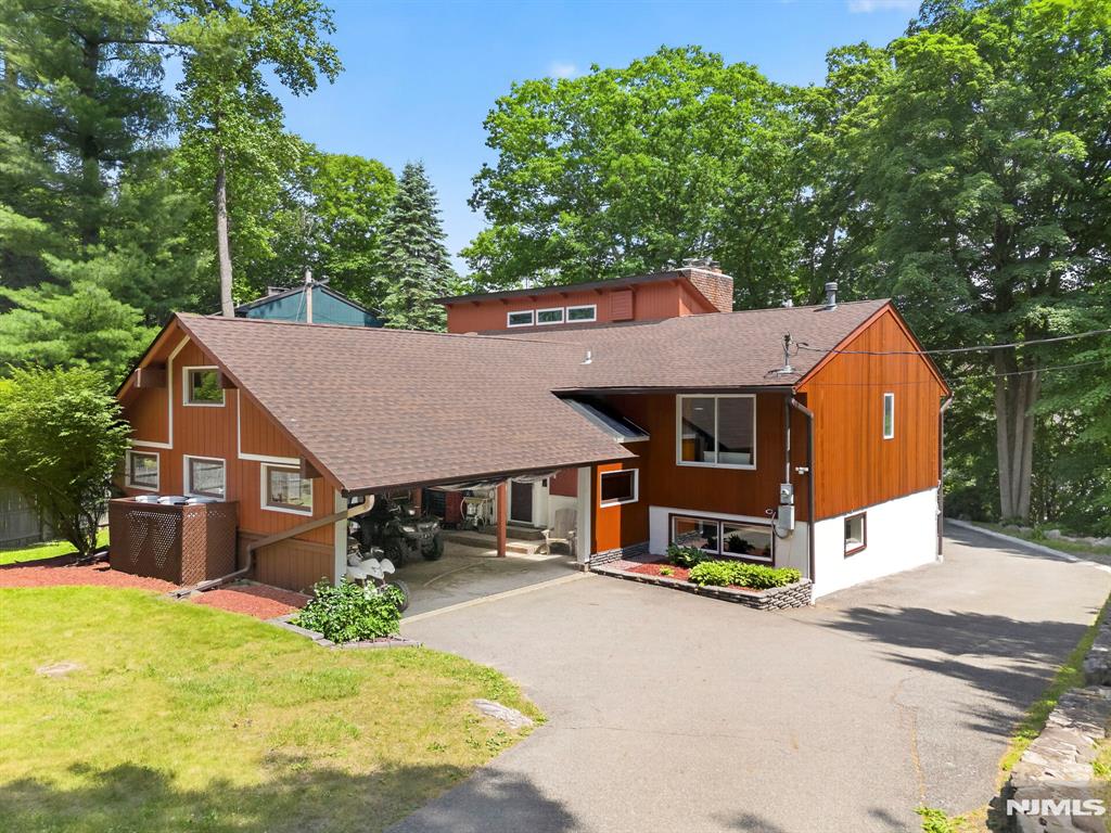Welcome to this 4-bedroom, 3-bath home perched on a hill with breathtaking views overlooking a beautiful lake community. Situated on nearly half an acre, this property offers the perfect blend of nature, recreation, and opportunity. Enjoy year-round outdoor adventures with easy access to nearby Waywayanda State Park, featuring over 60 miles of trails and a 255-acre lake for hiking, biking, snowmobiling, cross-country skiing, fishing, & more. Mountain Creek Resort is also just a short drive away, offering skiing, snowboarding, a water park, and mountain biking. Lookover Lake has a private beach, fishing, & social events. The recently painted exterior gives this home fantastic curb appeal & second-floor deck provides an even more spectacular stunning lake view.An oversized rear carport with abundant storage provides plenty of room for all your outdoor gear and recreational toys. Brand-new 6 inch gutters, leaders, leaf guards & roof with a 15-year warranty offers added peace of mind for years to come. Looking for flexibility? This unique home features a desirable layout, offering space for extended living arrangements, guests, or additional privacy. If desired, this home can be owner occupied or an investment opportunity. Located in the sought-after Lake Lookover community with convenient access to shopping & dining. Lake living, mountain adventures, and unforgettable million-dollar views. Come experience it for yourself. You don't want to miss this one!