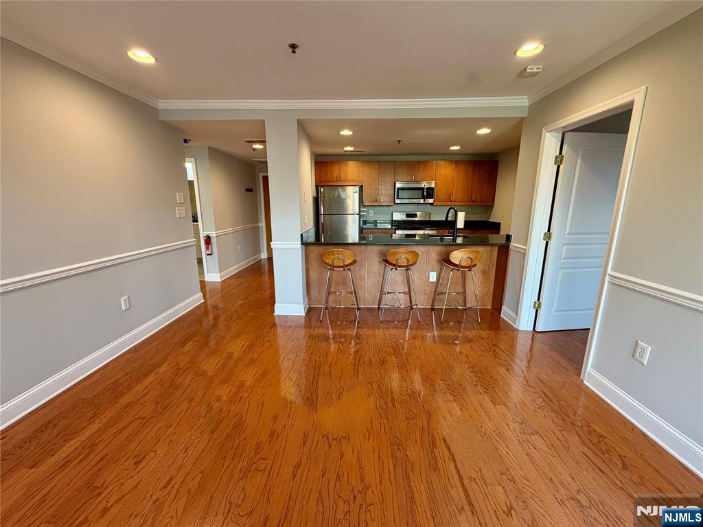 Love Hoboken? Experience comfort and convenience with this well cared for 2 bedroom, 1 bath condo with a modern open kitchen to the living area freshly painted and with moulding/trim. New sliding doors and a large window opens to a long balcony which faces the interior ( not street facing ) affording a quiet space and privacy. Large windows in the primary bedroom enable plenty of natural light and treetop views. The second bedroom features double closets - plenty of storage. The bathroom has a whirlpool tub, new cabinet, sink and faucet plus a beautiful storage mirror. Stainless steel appliances, granite counters, wood faced cabinets, Hardwood floors and newer LG W/D in unit - add to the contemporary feel. The modern brick and steel building also features an elevator, gym for residents and Butterfly MX intercom system. In unit parking may be available for a separate fee. Freshly painted, custom closets, central AC - this home is move in ready. Close proximity to the path, train, bus, parks and schools.