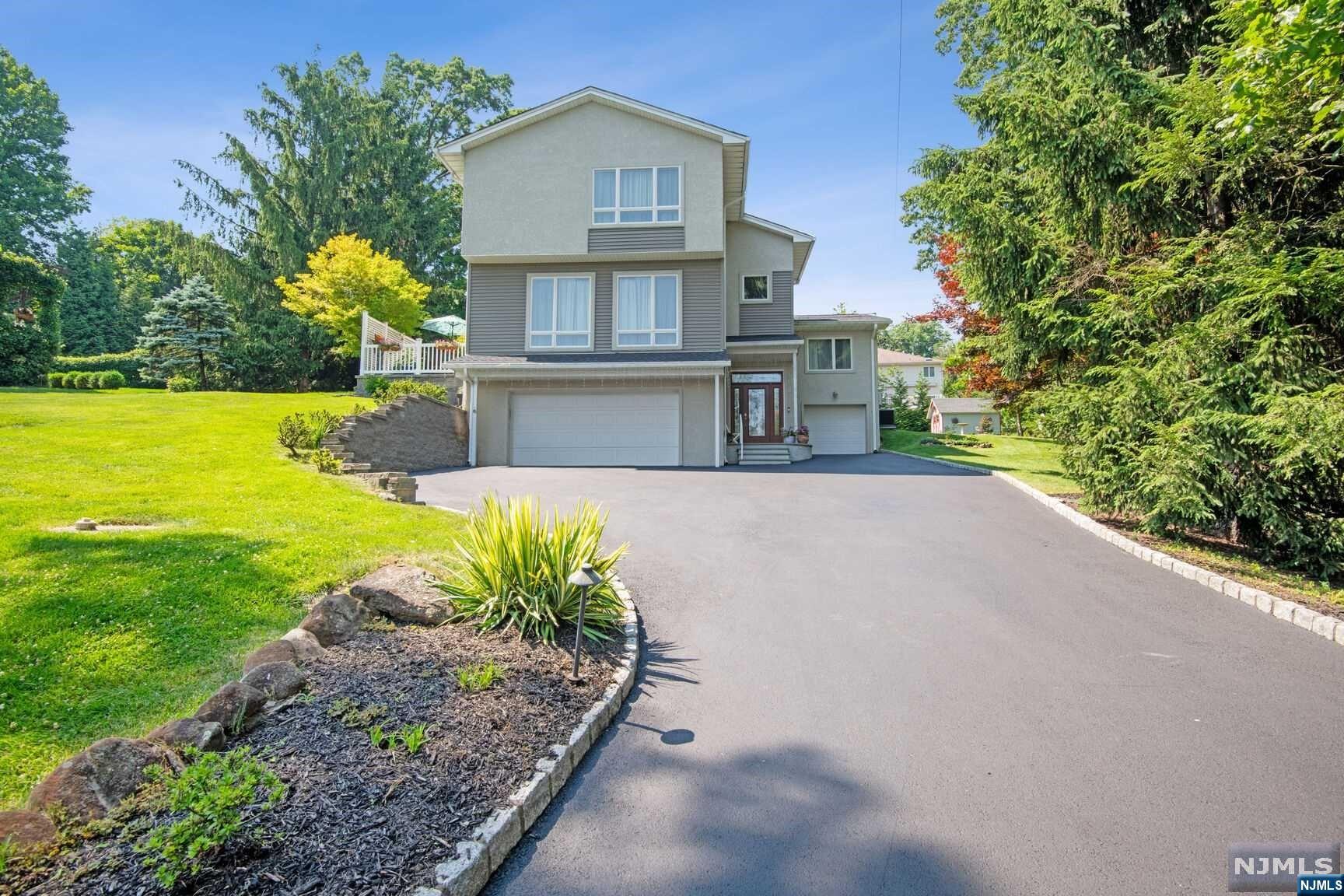 Perfect home for multi-generational living with home office space on no-thru street, 2-story main entry foyer takes you to the 2-car garage, finished basement walks out to built-in 1-car garage, and leads to the expansive main level living room with high ceilings and virtual fireplace. Stone deck off the living room. Open floor plan, and three steps, leads to dining room with wood burning fireplace and center island to the kitchen with breakfast room that leads to back patio and tranquil yard. To the right of the office nook is a powder room that serves guests, and to the left is the hallway that leads to 2 bedrooms and full bath. Upstairs features a wonderful primary suite that includes walk-in closet with organizers, and full bath with double sinks. Additional bedroom has separate full bath. Fin basement includes main room, and bonus room. Recessed lights, multi-zone heating and AC, underground sprinklers, outdoor lighting, solar panels, generator. Close to NYC bus. See 3D tour.