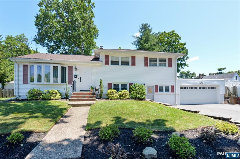Expanded split level on quiet dead end street! Large living room, modern kitchen with stainless steel GE and Frigidaire appliances, built-in second oven, raised work counter, ample ceiling height cabinets with Lazy Susans, tile backsplash. Kitchen opens to formal dining room with sliding glass doors to deck, paver patio and gorgeous private yard. Upstairs three good size bedrooms and main bath. Ground level expanded family room, spacious storage closets, 2nd full bath, laundry with Maytag washer and dryer, convenient entry to large 2 car garage! Beautiful hardwood floors, gas heat, separate central air conditioning, updated windows, upgraded 200 amp electric service, replacement staircases with easy wide steps, vinyl siding, newer steel 2 car garage door with auto opener and plenty of storage cabinets and built in shelving, extra freezer and refrigerator. Plenty of double wide driveway parking. Terrific location!