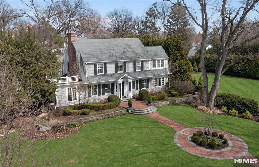 Set on coveted Phelps Road, this beautifully maintained Center Hall Colonial blends timeless elegance with modern conveniences for today's lifestyle. Just blocks from Willard Elementary, this 5-bedroom, 3.5-bath home begins with a gracious entry foyer leading to a transitional living/family room with a fireplace and French doors open to a sunroom or dedicated home office. The formal dining room flows seamlessly into the den and kitchen, creating an inviting setting for entertaining. The chef's eat-in kitchen showcases custom cabinetry, a center island, soapstone countertops, and a spacious breakfast area with glass doors to the backyard. A powder room and mudroom complete the main level. Upstairs, the primary suite consists of a full bath and a secluded office or potential oversized walk-in closet/dressing room, while the remainder of the 2nd and 3rd floor includes 4 additional bedrooms and 2 full baths. The expansive lower level provides a recreation room, gym space, and abundant storage. Professionally designed landscaping, along with brick and bluestone walkways, enhances the home's exceptional curb appeal, while the private backyard features generous play space, a large bluestone patio, a semi-half basketball court, and a 3-car garage. Ideally located near NYC transportation, top-rated schools, and downtown.