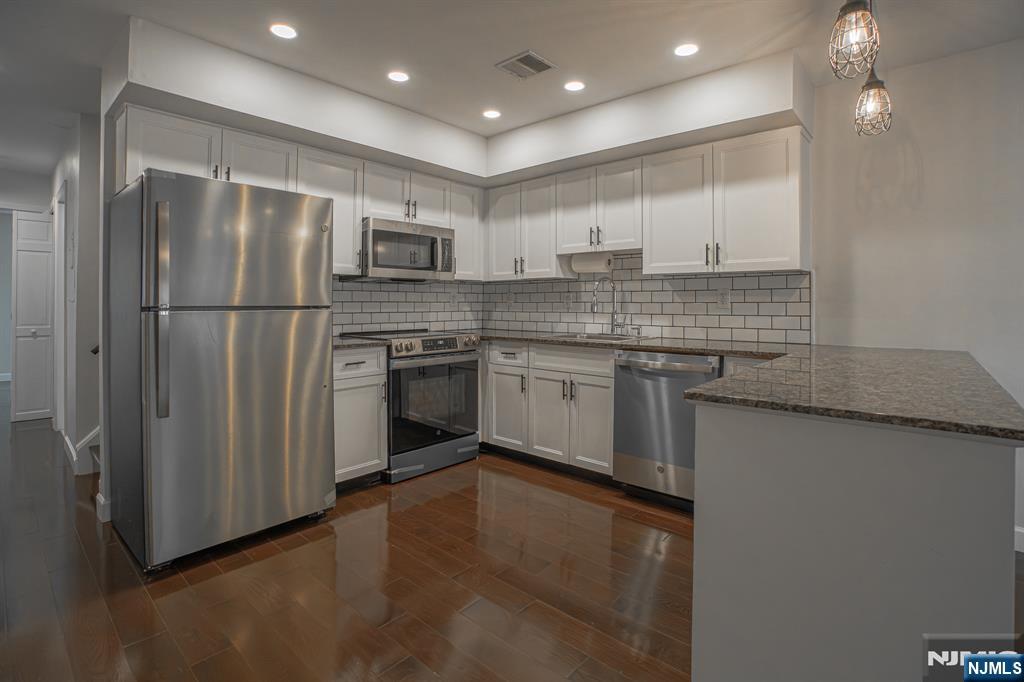 Welcome to this beautifully updated 2-bedroom, 2-bath condominium located in the highly desirable Fairmount section of Hackensack. Offering approximately 810 square feet of thoughtfully designed living space, this move-in-ready home combines modern updates, everyday convenience, & an unbeatable commuter location. Since purchasing the home, the owner has made numerous quality improvements throughout, including hardwood flooring throughout the entire unit, recessed lighting with updated electrical, a new hot water heater, fresh interior paint, custom closet shelving, and a beautifully refreshed kitchen featuring upgraded cabinet doors, new hardware, modern backsplash, & brand-new stainless steel appliances with the original tags attached. A Nest smart thermostat adds comfort & energy efficiency. The spacious living room opens to a private balcony, while the eat-in kitchen offers both functionality & style. The home also features two full bathrooms, in-unit laundry, generous storage, & two covered tandem parking spaces located beneath the buildingâ€”an uncommon convenience in this area. A private storage area is also available for an extra fee. Ideally situated just minutes from NJ Transit, major highways, Hackensack University Medical Center, shopping, restaurants, and parks, this exceptional condo offers the perfect blend of comfort, convenience, and low-maintenance living. Simply unpack & enjoy everything this beautifully updated home has to offer.