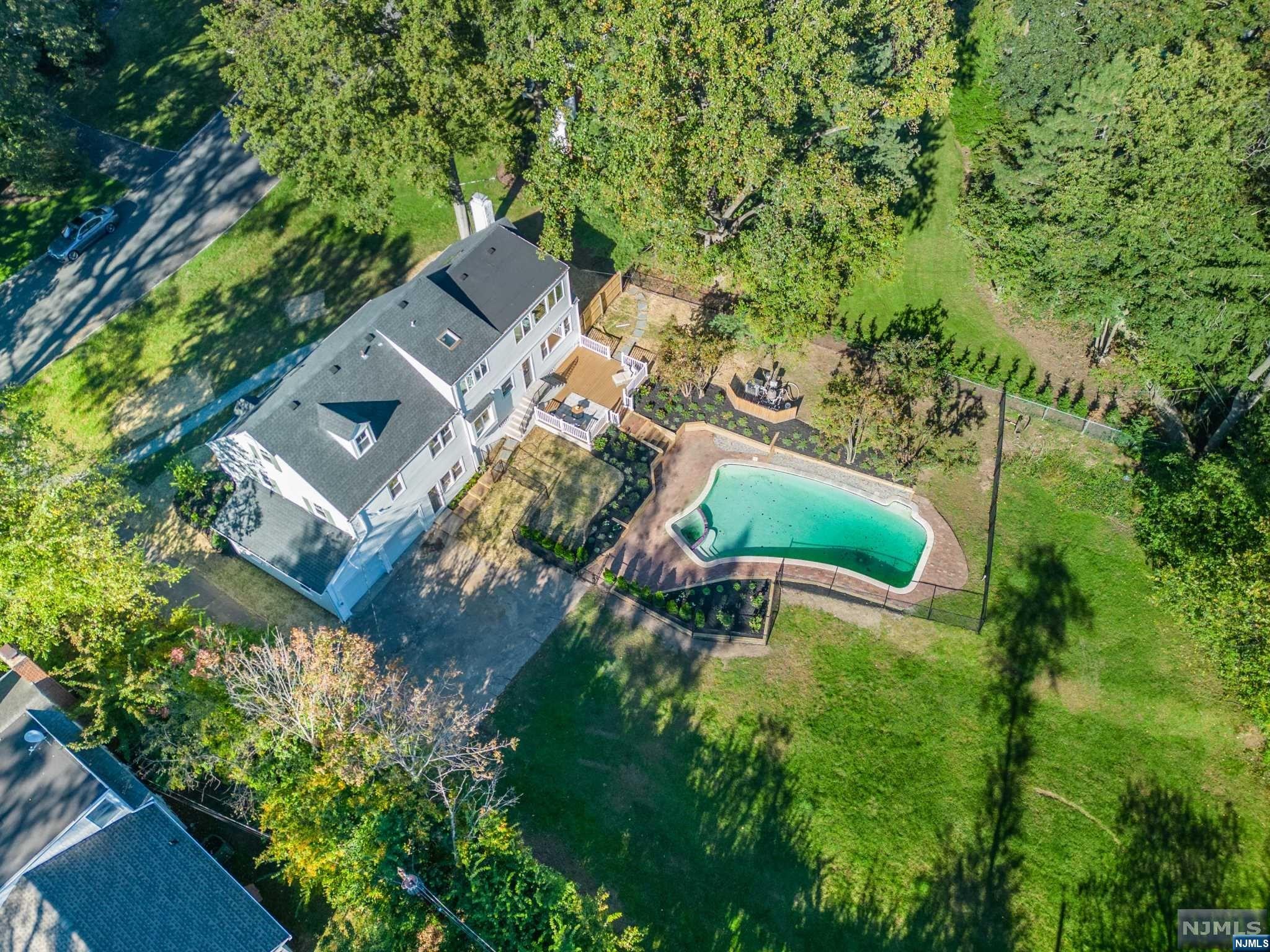 STUNNING COMPLETELY RENOVATED 6-BEDROOM COL ON HUGE LOT W/POOL. CLOSE TO NYC DIRECT TRAIN. Gorgeous state of the art kitchen w/ Bertazzoni 6-burner stove, Bertazzoni double-doored paneled fridge. Bosch dw, huge quartz center island w/pendant lighting & gold accents, plenty of cabinetry incl pantry & tons of windows! Approx 1/2 acre flat bkyrd w/pool & plenty of space for entertainment. Showpiece living room has floor to ceiling built-ins & wb fireplace. 2nd flr boasts four bedrooms + newly renovated main bath. Gracious, sunfilled primary bdrm on 3rd lvl includes skylight, sitting area overlooking bkyrd & pool. Freestanding egg-shaped soaking tub, double sinks, skylight, glass-doored shower, elegant floor tiles & fixtures. Lwr level is perfect fam rm + there's a convenient full bath attached. MORE room in fully fin bsmt...can be playroom, pool room, guest room, endless possibilities. Gas heat, AC, HW flrs, 2-car garage. Enjoy 3 parks all less than a 1/2 mile away.
