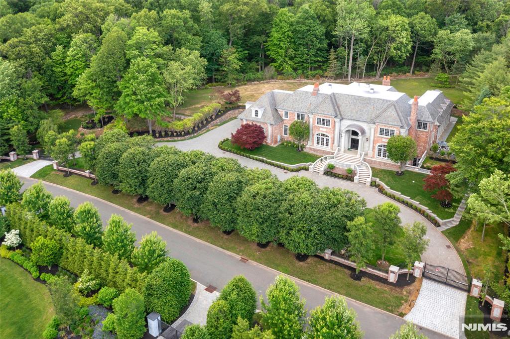 This Alpine estate on a private cul-de-sac street on 2.35 AC, Timeless elegance and unparalleled luxury, Quality crafted, this gated masterpiece boasts a stately slate roof, a sweeping circular driveway, an opulent indoor pool, 2 story EF w/marble detailing, mahogany wood library/FPL/coffered ceiling, formal Dr/FPL/ butler's pantry, a sprawling great rm/FPL, custom built-ins and Fr. doors to inside and outdoors, Kit with breakfast & sitting area ,sits at the center of the home, w/ Fr. doors to private patio, en- suite guest Bed rm, a spa-like pool area and 1/2 bath complete the main level, Second level 2 master suites w/sitting rms & FPLS, 3 additional en-suite Bed rms, Lower level has outdoor access, theater, bar, great rm, Elevator, Much more!