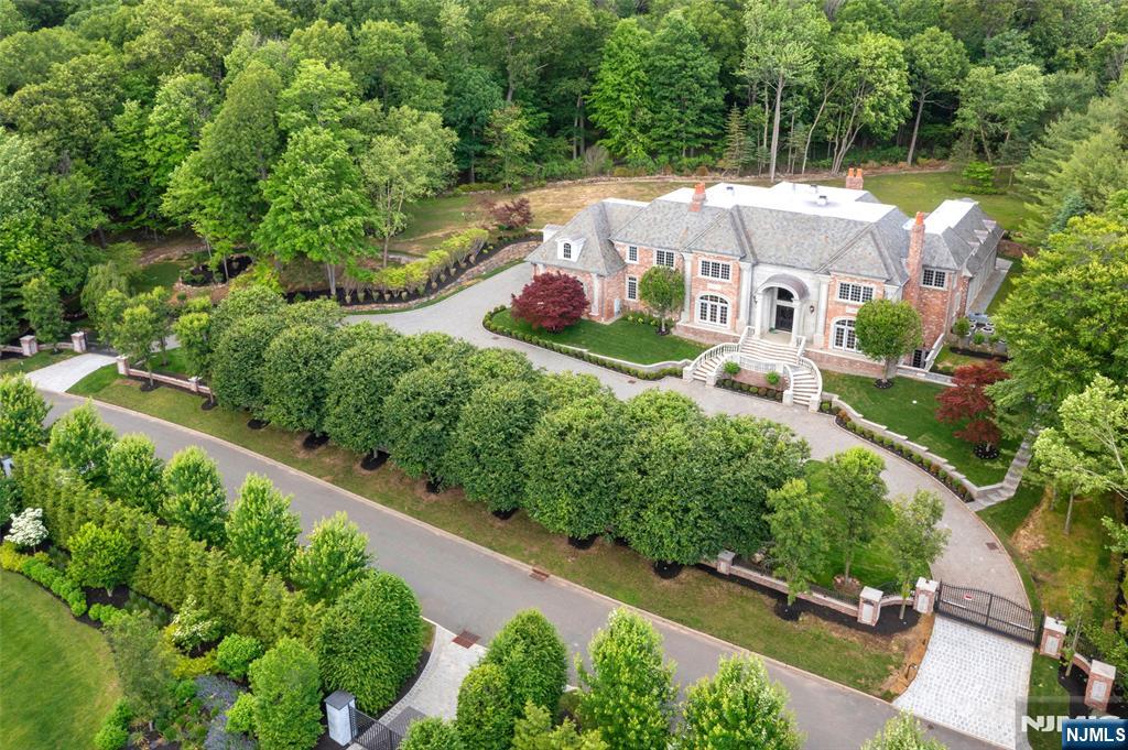 This Alpine estate on a private cul-de-sac street on 2.35 AC, Timeless elegance and unparalleled luxury, Quality crafted, this gated masterpiece boasts a stately slate roof, a sweeping circular driveway, an opulent indoor pool, 2 story EF w/marble detailing, mahogany wood library/FPL/coffered ceiling, formal Dr/FPL/ butler's pantry, a sprawling great rm/FPL, custom built-ins and Fr. doors to inside and outdoors, Kit with breakfast & sitting area ,sits at the center of the home, w/ Fr. doors to private patio, en- suite guest Bed rm, a spa-like pool area and 1/2 bath complete the main level, Second level 2 master suites w/sitting rms & FPLS, 3 additional en-suite Bed rms, Lower level has outdoor access, theater, bar, great rm, Elevator, Much more!