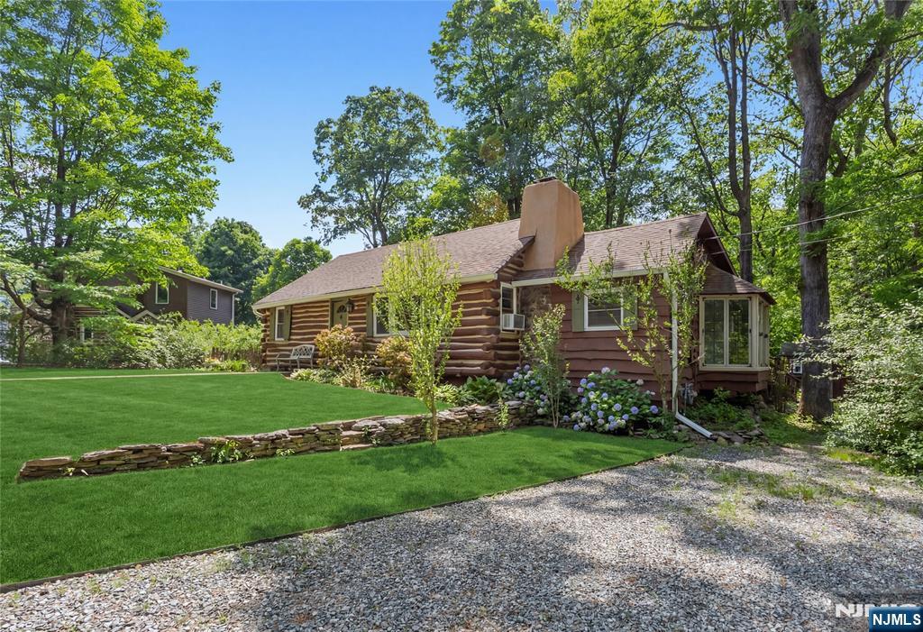 A rare blend of rustic charm and timeless character in the heart of sought-after Fayson Lakes. Welcome to 6 Partridge Trail, an expanded 3-bedroom, 2-bath log cabin home set on a large, flat lot in one of Kinnelon's most desirable lake communities. This unique home showcases authentic log construction paired with warm wood finishes, creating a cozy yet spacious retreat. Step inside to a stunning open-concept living area with soaring vaulted ceilings, exposed beams, and a dramatic stone fireplace, the true centerpiece of the home. Natural light pours in through oversized windows, while the adjoining dining area features a charming bay window overlooking the property. The kitchen offers rustic cabinetry and a functional layout ready for your personal touch. A standout feature is the classic Fayson Lakes sleeping loft, accessed by a spiral staircase. Perfect as a guest space, home office, or creative retreat. Outside, enjoy a spacious deck ideal for entertaining and a peaceful backyard surrounded by natural beauty. Located in the coveted Fayson Lakes community, residents enjoy access to lakes, beaches, and a true neighborhood lifestyle. A rare opportunity to own a character-filled home in a prime location!