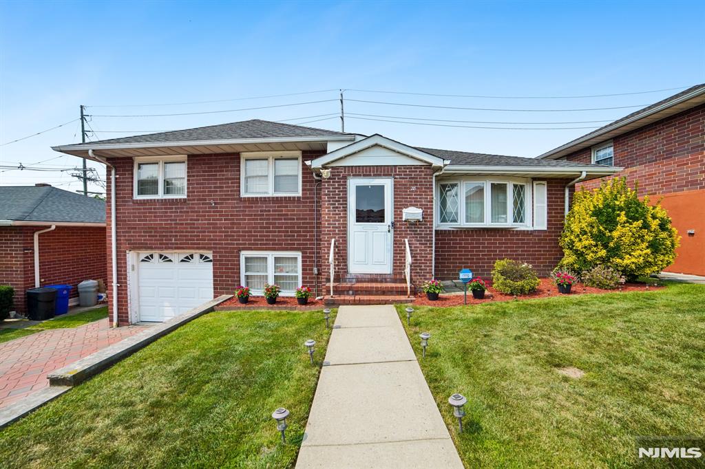 Opportunity knocks on Pikeview Terrace! Located in a highly desirable Secaucus neighborhood, this solid brick-front home is a rare find and the perfect blank canvas for those looking to customize their dream space. Maintaining its "original" charm, the interior features classic hardwood floors throughout the functional layout, offering 2 bedrooms and 2 full bathrooms. The first level multi purpose family room provides excellent bonus space. Just steps away is the lower-level recreation room, complete with vintage custom bar and rich wood paneling. Outside, you will find fantastic curb appeal, a convenient one-car garage and spacious open back yard with a patio that's tailor made for summer entertaining. The home is just a short train ride to Manhattan and is perfectly situated for transit, shopping and dining in NYC. Unlock the true potential value of this well-located property gem! Home being offered strictly as is.