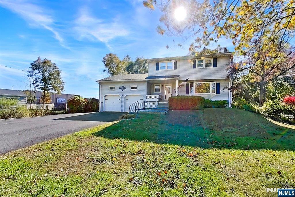 Welcome to this beautifully maintained 4-bedroom, 2-bath colonial featuring a new roof, new front steps, and custom rails. Inside, you'll find hardwood floors throughout, a kitchen with granite countertops, appliances, and a living room highlighted by custom distressed ceiling beams and a full stone gas fireplace with built-in shelving and TV hook. The home offers a full basement with new windows, a workshop, and walkout access to the backyard. Enjoy the expansive two-tier deck with a custom tiki bar, perfect for entertaining. The outdoor space includes two storage sheds, extensive landscaping. Additional features: 2-car garage with loft storage and ceiling height for a car lift, Driveway parking for up to 6 cars. This one-of-a-kind property combines charm, functionality, and ample space for both indoor and outdoor living. The roof was replaced in 2024. (House sold as is) There is a car lift for additional cost.
