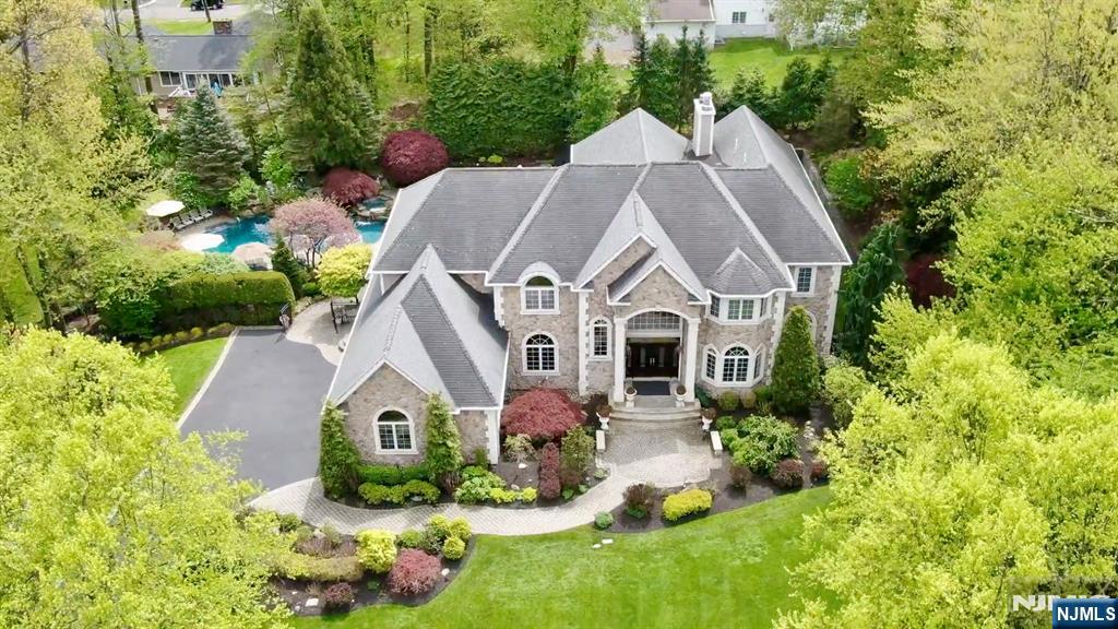 Set within one of Franklin Lakes most prestigious neighborhoods, this exquisite stone manor is a statement of timeless elegance and resort-style living. Sited on a great property it offers extraordinary outdoor entertaining space featuring pool with 5 waterfalls, spa and outdoor kitchen, capturing the culture and lifestyle of this distinguished residence. An inviting interior begins with a 2 story entry foyer, with sweeping curved staircase, custom Italian tile floor flowing into an impressive family room with extensive custom millwork, fireplace, corner wet bar and French doors opening to the patio and grounds beyond. The chefâ€™s kitchen is truly the heart of the home, offering a substantial center island, abundant custom cabinetry, and separate breakfast area enhanced by hand-painted murals. The main level also features a spacious formal dining room, elegant living room, laundry, office, and 1st floor bedroom with full bath. An additional first floor kitchen provides flexibility for entertaining, kosher use, or a thoughtfully designed first-floor in-law suite. Second level reveals a luxurious primary suite wing, complete with fireplace, sitting room, 2 walk-in closets, and spa-like bathroom. 3 additional en-suite bedrooms complete this level. An Entertainerâ€™s dream basement offers a recreation room, mahogany bar, 3rd kitchen, gym with sauna, bedroom 6, full bath, and storage. A truly exceptional home offering sophistication, scale, and unmatched lifestyle in Franklin Lak