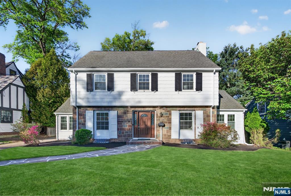 Exceptional Center Hall Colonial nestled in the highly sought-after Knollwood section of Short Hills, just blocks from vibrant downtown Millburn, Midtown Direct trains to New York City, and top-rated Millburn schools. Filled with natural light, the living room features newer windows, a classic wood-burning fireplace and elegant French doors opening to a den or home office. The den offers newly installed carpeting, recessed lighting and walls of windows overlooking the beautiful front and back yards. The formal dining room is rich in timeless charm with chair rail molding and abundant sunlight. The beautifully updated eat-in kitchen showcases white cabinetry, quartz countertops, stainless steel appliances, breakfast island, separate dining area + direct access to the sunroom, private backyard with breezeway 2-car garage. Upstairs, the spacious primary suite features hardwood floors, walk-in cedar closet and a newly renovated bath with sleek finishes and floating vanity. Additional bedrooms are bright and generously sized with hardwood floors and ample closet space, while the updated hall bath is finished in travertine marble. The 3rd floor adds two flexible rooms perfect for bedrooms, offices, or guest space. The freshly painted lower level provides new carpeting, exceptional storage, utility space + walkout access. With extensive updates + unbeatable location near shopping, dining, transportation and Newark Airport, 85 Whitney Rd offers the best of refined suburban living