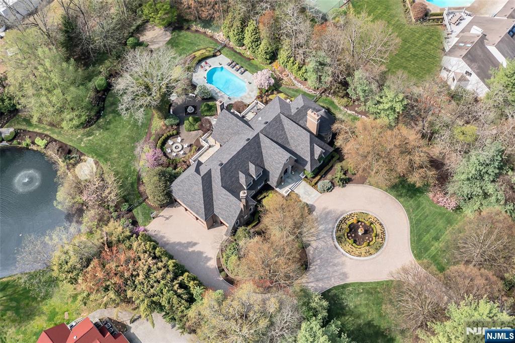 Masterfully designed, this sprawling English Country Manor seamlessly blends modern elegance, timeless architecture, and exceptional custom millwork. Set on 2 serene acres, nearly every inch of this 9,200 SF estate, complemented by a 2,400 SF lower level, has been elevated with updates and exquisite interiors by renowned designer Jennifer McGee. A grand foyer with Grecian marble floors and a sweeping bridal staircase introduces an expansive layout designed for refined entertaining. The dramatic 2-story great room, anchored by a sophisticated wet bar and double French doors, flows effortlessly into a gourmet chefâ€™s kitchen with custom cabinetry, oversized island, La Cornue Chateau 120 range, and radiant heated floors. The main level is further enhanced by a banquet-sized dining room, private office, and living/billiard room with stunning traditional details. The primary suite, immaculately renovated in 2024, is a true sanctuary boasting a fireplace, sitting room, oversized dressing room, and spa-like bathroom that is a masterwork of design, featuring a sauna, freestanding jacuzzi and radiant heat. Upstairs, 5 spacious bedrooms and a full laundry room provide comfort and convenience. Expansive lower level includes a temp-controlled wine cellar, gym, rec room, media room, and access to the heated 6-car garage. Outdoors, resort-style grounds showcase tranquil pond views, manicured gardens, a heated Gunite pool, bluestone patios and fire pit. Unmatched prestige & privacy await!