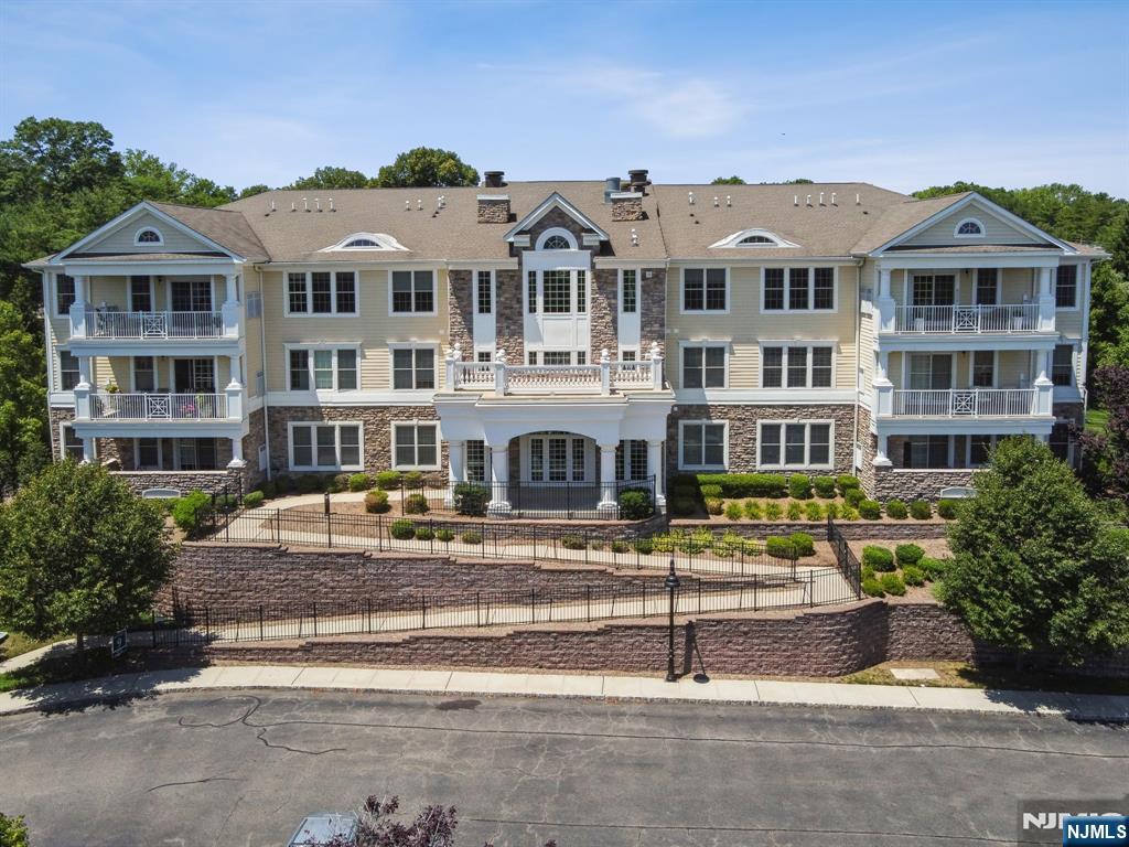 Welcome to effortless luxury at Four Seasons at Ridgemont, one of Bergen County's most prestigious 55+ communities. This beautifully updated, move-in ready first-floor residence offers nearly 2,000 square feet of sophisticated one-level living with a bright, open layout designed for both comfort and entertaining. A gracious foyer opens to sun-filled living and dining areas. The updated kitchen features granite countertops, stainless steel appliances, a large center island, pantry, desk area, and abundant cabinetry. It flows seamlessly into the inviting family room with a gas fireplace and sliding glass doors leading to a private covered balcony. The spacious primary suite is a private retreat with a tray ceiling, two walk-in closets, & a spa-inspired bath with a double vanity and oversized shower. A generously sized second bedroom and full bath provide the perfect space for guests or a home office. Additional highlights include in-unit laundry, elevator access, one deeded underground parking space, and private storage. Enjoy resort-style amenities including a clubhouse, outdoor pool, fitness center, putting green, and beautifully landscaped grounds. Ideally located near Tice's Corner Marketplace, Whole Foods, premier shopping, exceptional dining, major highways, and NYC transportation, this exceptional home offers the perfect blend of luxury, convenience, and carefree, maintenance-free living. Simply unpack, relax, and enjoy everything Four Seasons at Ridgemont has to offer.