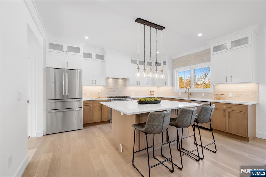 Stunning brand new construction colonial built over existing foundation in ultra-desirable Tenafly! This beautiful home offers 4 bedrooms, 4.5 bathrooms, and gorgeous finishes throughout. Enter into a spacious family room with wall of custom built-ins and continue into the designer kitchen featuring a huge center island, beautiful countertops, and professional-grade stainless steel appliances. The kitchen flows seamlessly into the large dining room, creating an ideal layout for everyday living and entertaining. A powder room, mud room, and attached 1-car garage complete the main level. Upstairs, the dreamy primary suite features 2 walk-in-closets and a spa-like bathroom with double vanity. A junior suite, two additional bedrooms, a beautiful full hallway bath, and laundry complete the second floor. The finished basement offers a large recreation room and an additional full bathroom, providing flexible bonus space. Complete with a 1-car attached garage and an idyllic backyard setting, this home offers the perfect blend of style, comfort, and convenience. Absolutely nothing to do but move right into this gorgeous Tenafly home, ideally located in a wonderful community with top-rated schools.