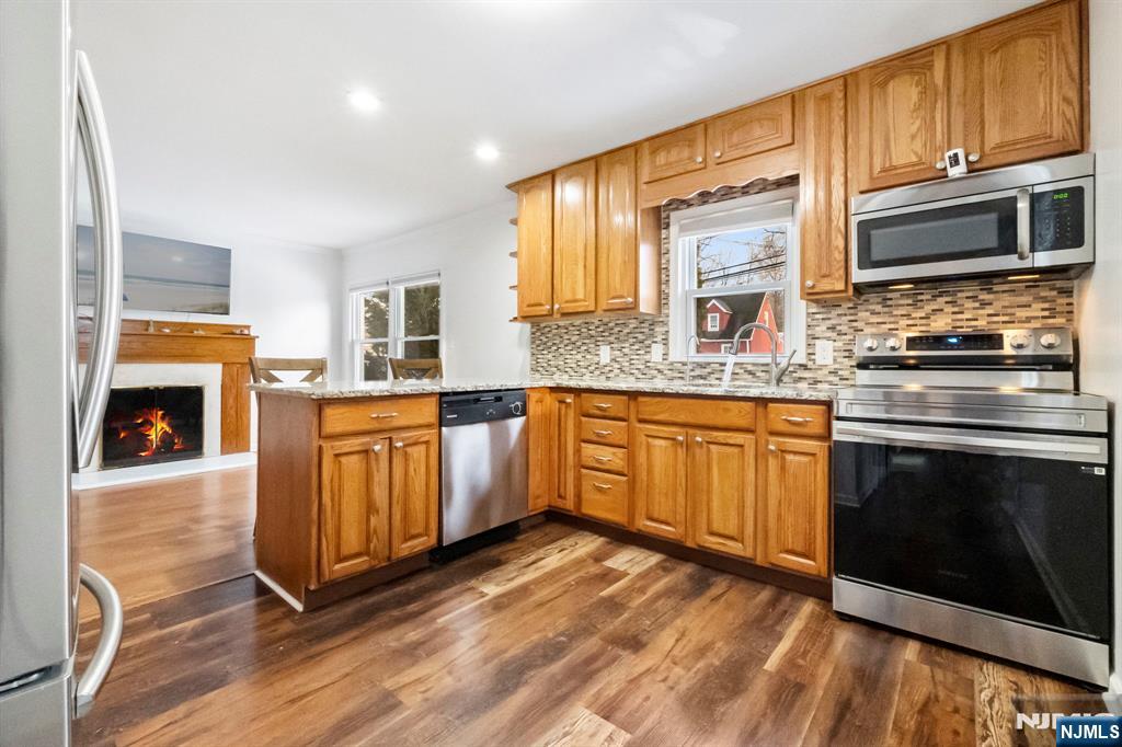 PRICE IMPROVED!!! Move right into this beautifully updated Cape just minutes from the lake! This inviting home features an open-concept kitchen with granite countertops, stainless steel appliances, and a breakfast bar overlooking the dining area with a cozy wood-burning fireplace. The bright living room opens to a spacious deck with built-in seating and beautiful lake views. A first-floor bedroom and updated full bath with a stunning tiled walk-in shower offer convenience and flexibility. Upstairs, you'll find two additional bedrooms plus a bonus space ideal for a home office or extra storage. The finished walk-out basement includes two versatile bonus rooms and a second full bathroom, providing plenty of space for a family room, office, gym, or guests. Enjoy a private fenced backyard, newer furnace, water softener, and energy-saving solar panels. Conveniently located near Routes 80, 46, and 23, this move-in ready home offers the perfect combination of comfort, convenience, and value! Don't miss your opportunity to make it yours! Sold As Is - No known Issues. Buyers to verify all dues with Lake Telemark.