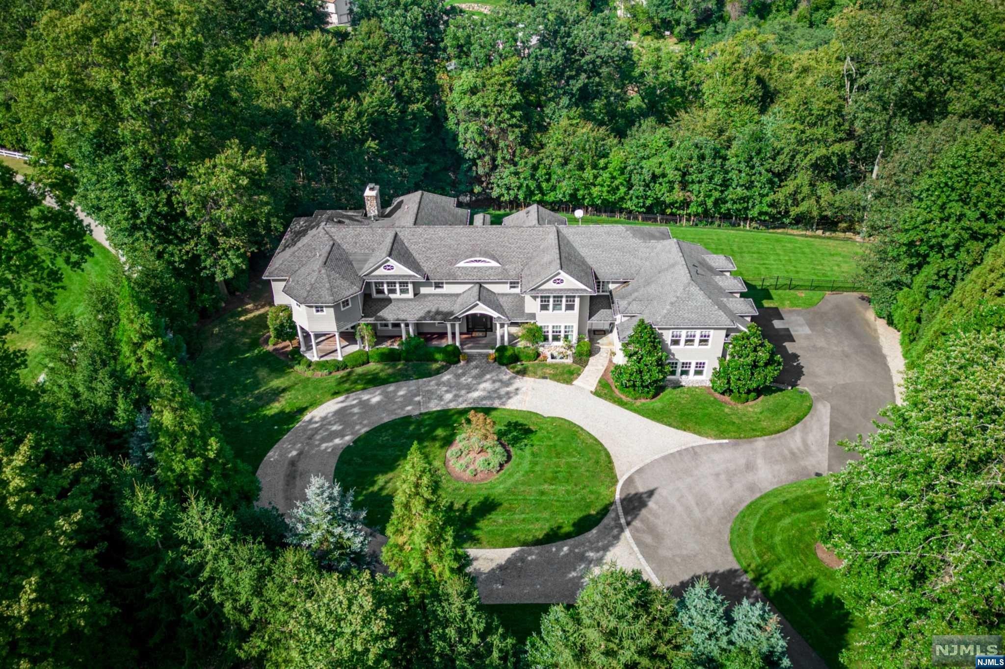 One of a kind bespoke Ridgewood offering. Custom built, 20-year-young, Hampton style colonial with over 7,300 SF of high-style interior design elements and 360-degree privacy spanning over an acre of flat land. Upon entering you'll feel like you've stepped straight into the pages of Architectural Digest. High-end everything in the newly updated custom kitchen with all luxury brand appliances, 10-foot center island, pantry with wine cellar, and vaulted ceiling breakfast nook. Other notable first-floor features include a Banquet-size dining room, a grand 2-story entry, a secluded office, and walls of windows and French doors leading to a wrap-around partially-screened side porch and back deck. The 2nd level with 5 bedrooms, all ensuite, including a tranquil primary retreat with fireplace, new spa-like bath & large second family room/game room. Newly painted exterior, walk-out finished basement, home theatre, and located in the desirable Willard section of Ridgewood.