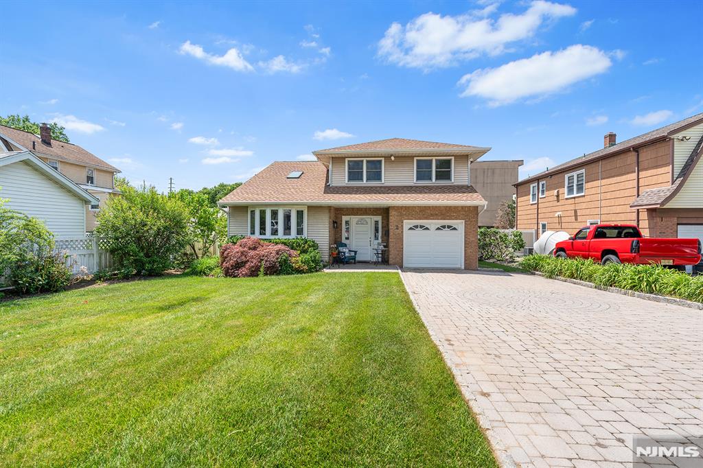 Beautifully maintained split-level tucked at the end of a quiet Bergenfield cul-de-sac. The home has a unified roofline, giving elegant curb appeal and sophistication you won't find in a typical split. Inside, a tiled foyer opens to a layout that balances bright, open living with private, dedicated spaces. The sunken living room is bathed in eastern and southern light and flows up to a dining room that overlooks it from behind a graceful railing. The kitchen is full of character, anchored by a flawless vintage range that still works like the day it was built, with gleaming hardwood floors running throughout. A rear family room steps out to a paver patio and a fenced yard on a deep 50x150 lot, with rare privacy: no windows overlook the backyard from behind. Upstairs are three bedrooms including a primary with dual closets, plus the full bath. Additionally, there is a half bath, an attached garage, and a pristine, bone-dry basement with a smooth concrete floor ready for your vision. Cared for by one owner for decades, the home is exceptionally clean, solid, and truly move-in ready, with timeless bones waiting for your personal touch. Steps to express NYC buses, shopping, dining, houses of worship, schools, and everyday conveniences. Homes that are this well-kept in excellent locations do not last.