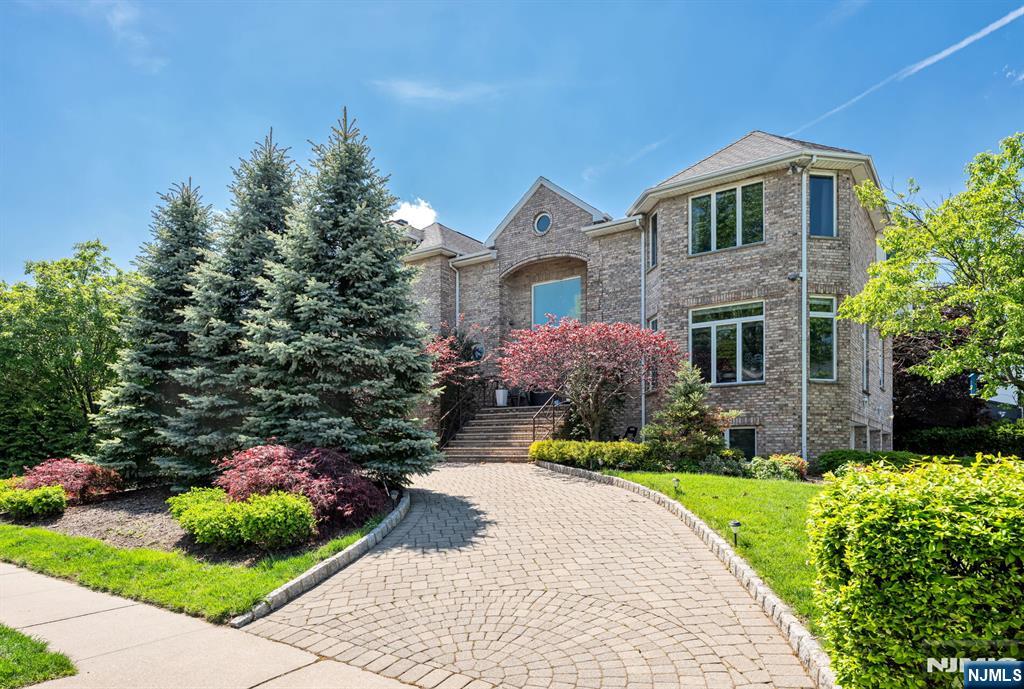 Welcome to the sought-after Bluff section of Fort Lee. East-facing Manhattan skyline views from the George Washington Bridge to Midtown. Primary suite with NYC view, fireplace, and marble spa bath. Brick Center Hall Colonial in the Bluff Section of Fort Lee. 5-bed, 4.5-bath at 1115 Arcadian Way, Fort Lee, NJ 07024. Approx. 3,904 sqft, corner lot, built 1997, renovated 2011. Primary suite: tray ceiling, picture window NYC skyline view, gas fireplace, sitting room, marble spa bath with freestanding tub, frameless rainfall shower, double vanity. Chef's kitchen: Poggenpohl Wenge cabinetry, Caesarstone counters, white quartz waterfall island, Wolf 6-burner gas range, Sub-Zero fridge, wine column, induction cooktop, slider to deck with electric awning. Two fireplaces. Two-story foyer with limestone stairs, ironwork railing, Venetian plaster. Custom Wenge doors. Central air, central vacuum.. First floor: living, dining, family room, 5th bedroom, powder room, laundry, home office. Second: primary suite with bedroom and ensuite; two bedrooms sharing a Carrara bath. Walkout ground level: rec room, den, full bath, mudroom, attached 3-car garage. Exterior: paver circular drive, raised deck, paver patio, half-court basketball, fenced yard, evergreen privacy hedges. Bluff Section of Fort Lee. Minutes to GWB ramp, NJ Transit bus to Port Authority Bus Terminal, Fort Lee Public Schools, Palisades Interstate Park, Hudson Lights, Route 4. Sitting right above the Edgewater riverfront community.