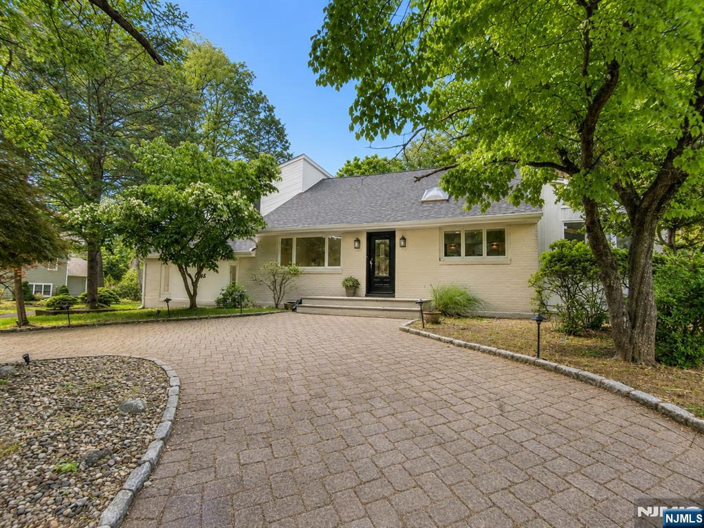 Welcome to 1 Herrick Drive, a distinctive 4-bedroom, 3 full bath, 2 half bath residence offering exceptional living space, architectural character, and extensive recent updates in one of Old Tappans most desirable locations. Ideally situated within walking distance to top-rated schools, library, shopping, and transportation, this home features a bright & versatile floor plan highlighted by soaring ceilings, skylights, and abundant natural light throughout. Recent improvements: renovated bathrooms, new carpet and flooring, updated quartz kitchen counters, and new roof installed in January w/ warranty. The oversized primary suite offers vaulted ceilings, skylights, generous closet space, and direct access to private deck. Beautifully renovated primary bathroom features freestanding soaking tub, frameless glass shower, dual vanity, and contemporary finishes. Updated kitchen opens to dining and living areas, creating an inviting setting for everyday living and entertaining. Dramatic great room with soaring ceilings, den & full bath provides exceptional flexibility for recreation, fitness, guests, work-from-home needs, or multigenerational living. Additional highlights: bright sunroom w/ expansive glass and backyard views, stainless appliances, municipal sewers, circular driveway, and spacious property setting. A rare opportunity to own a move-in-ready home with substantial living space, major recent upgrades, and a unique contemporary design in sought-after Old Tappan.