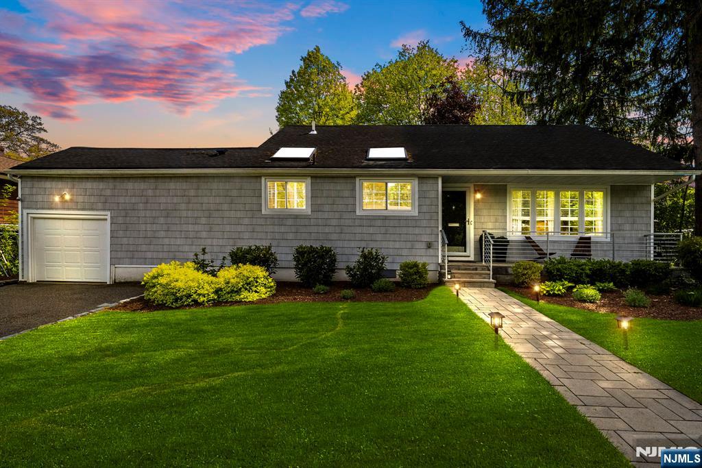 Tucked into Montclair's sought-after South End, this home offers the kind of quiet, settled feel that's hard to find. It features 3brm, 2.5bth & sits on a nearly quarter-acre lot, where three skylights and generous windows bathe the home in natural light from morning through evening. The kitchen anchors the main level with a quartzite waterfall island, stainless appliances, and white shaker cabinets, all beneath a vaulted, skylit ceiling that makes the space feel effortlessly open. A private home office just off the kitchen offers its own skylit retreat. A linear gas fireplace, hardwood floors, smart home controls, & a beautifully finished powder room carry the warmth through the rest of the main level. Upstairs, 3 bdrm & a full bth offer comfortable, well-proportioned living. The lower level is where the home truly opens up. A finished, multifunctional space that works as hard as you need it to, whether that's a 2nd home office, a gym, a media rm, or all three at once. A wine fridge, full bth, & a dedicated laundry round out a level designed for real life, with direct access to the backyard when the day calls for it. the yard has mature canopy trees, lush garden beds, a stone patio, and a wide open lawn create a private, park-like setting that feels genuinely removed rare at this price in Montclair's South End.Nishuane School and Nishuane Park are nearby. NYC transportation is close at hand. Downtown Montclair is easily within reach.
