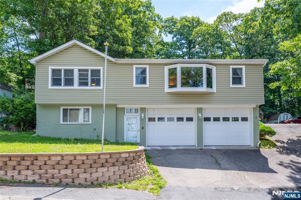 Welcome to 335 Elmira Trail, a spacious Hopatcong raised ranch offering the kind of flexibility that is hard to find in this price range. Set just minutes from Lake Hopatcong, this 3-bedroom, 2.5-bath home features generous living space, comfortable room sizes, hardwood flooring, and a bright main living area filled with natural light.The updated eat-in kitchen offers high ceilings, a skylight, breakfast bar seating, and an easy connection to the formal dining area, creating a practical layout for everyday living and entertaining. Outside, the home continues to impress with a private deck, backyard gathering space, storage shed, and extensive parking.A major highlight is the oversized heated garage and driveway setup, offering parking for 12+ vehicles with additional side driveway space. This is an ideal setup for car enthusiasts, contractors, tradespeople, hobbyists, boat owners, or anyone needing extra room for vehicles, tools, equipment, or recreational storage.Recent improvements include renovated bathrooms, newer furnace, mini-split air conditioning, whole-house water filtration system, and water softener. Enjoy convenient access to Route 80, Route 46, Route 10, and all that the Lake Hopatcong area has to offer, including boating, fishing, beaches, waterfront dining, hiking, skiing, golf, and year-round recreation . A standout opportunity for buyers looking for space, updates, parking, and lifestyle in one complete affordable package.