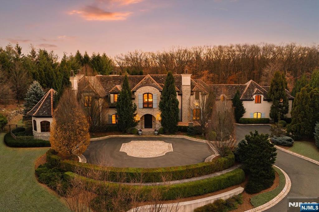 Visit https://184-vaccaro.com/ to explore the full luxury of 184 Vaccaro Drive. Spanning approx. 12k sq. ft., featuring 7 BDRMS, 8 full baths, 3 half baths, & 5 car garage. Blending luxury & modern comfort, its European inspired architecture is reflected in the stone facade and soaring ceilings. Inside, Venetian plaster walls, exposed beams, limestone FPLs and wide plank wood flrs create a warm, inviting atmosphere. Set on 1.833 acres, the home offers ultimate seclusion w/unparalleled views of the woodlands and sunset vistas. Its grand setback enhances privacy, reminiscent of European estates. Outdoor living shines w/a covered loggia, stone archways, wood-paneled ceilings, and FPL, fostering seamless indoor-outdoor living, and salt water pool/spa. Multiple al fresco dining areas offer ideal spaces for entertaining, while full guest quarters provide lux accommodations. Located just 9.1 miles from NYC in a coveted area, this estate blends privacy, luxury, & convenience.
