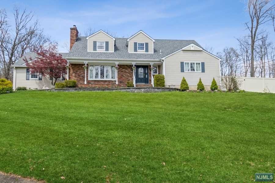 Spectacular expanded home sits on acre of parklike property bordering Green Acres. 4 bedrooms, 3.5 baths, & an attached 2-car garage, this picture perfect home is a true gem inside & out. Distinctive features include hardwood floors, elegant crown molding & trim, free-flowing entertaining & living spaces bathed in light, & a soft sophisticated neutral decor. Dramatic two-story foyer opens to formal living roof with fireplace & large bow window. Decorative columns mark the threshold into adjoining family room & banquet-sized formal dining room, both adorned with wainscoting. Spacious updated kitchen has granite counters, extensive cabinetry, SS appliances, oversized center island, & skylights bringing in the sun. Breakfast area features rustic stone fireplace with cozy window seat & sliding glass doors to a sprawling patio. With views of the manicured grounds & woods beyond, the private back yard has a beautiful built-in 3-stage firepit & paver patio.
