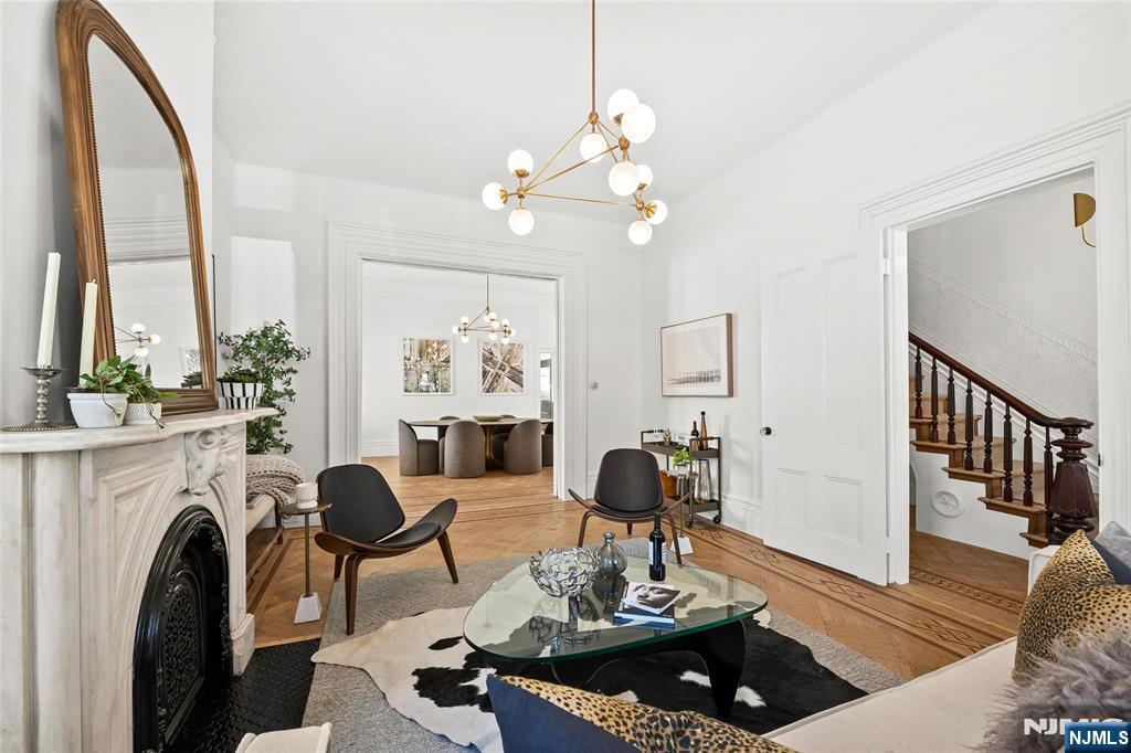 Experience the grandeur of this rare, newly renovated Queen Anneâ€“style Victorian with porch, set on an oversized lot on one of Jersey City Heightsâ€™ most picturesque blocks. This expansive 7-bedroom, 4.5-bath pre-war home blends original charm with modern functionality, exceptional scale, and rare parking. Original hardwood doors and trim welcome you into a space filled with timeless detail, including refinished parquet inlay floors, crown molding, 11â€™ ceilings, and preserved pocket doors connecting the living and dining areas. The living room features a carved marble mantle, while oversized windows and a bay alcove flood the dining room with natural light. A Lincrusta chair rail enhances the historic appeal. The kitchen offers custom cabinetry, a Sub-Zero refrigerator, 6-burner Wolf stove, vented hood, Sharp microwave, Viking dishwasher, and wine fridge, plus an adjacent sunroom. The second level includes a spacious primary suite with ample closets and a spa-like en-suite bath with double vanity, soaking tub, and glass shower, plus two bedrooms and a full bath. The third floor adds three bedrooms, a laundry room with LG washer/dryer, and a full bath with NYC skyline views. The finished ground floor offers a 1-bedroom, 1-bath suite with Bosch appliancesâ€”ideal for guests or extended living. Outside, enjoy a landscaped yard, 2-car garage, and parking for 4â€“5 cars. Near Pershing Field, Central Ave, and NYC transitâ€”this is a rare opportunity to own Jersey City history.