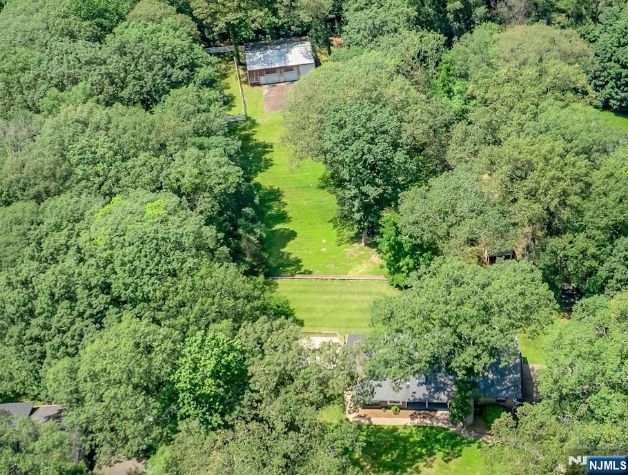 Welcome to this charming 3-Bedroom Ranch tucked away on just under 4 picturesque acres. This beautifully maintained 3-bedroom ranch offers comfort, space, and charm both inside and out. The Kitchen and Dining areas feature cathedral ceilings accented with rich wood planking. Skylights flood the space with natural light, highlighting the gleaming hardwood floors adding warmth and elegance to the space. A bright 3-season room just off the Breakfast area invites you to relax while enjoying panoramic views of the property, with direct access to a large deck-perfect for outdoor entertaining. The spacious Family Room offers a cozy wood-burning fireplace and access to its own private deck, making it an inviting retreat year-round.The bedroom wing includes two comfortable bedrooms serviced by a full bath, while the Primary Bedroom boasts an updated private bath and its own balcony overlooking the lush grounds.The finished walk-out basement expands your living space with a Recreation Room complete with a fireplace, a full bath/laundry room, an exercise area and direct access to the 2-car garage. Outdoors, enjoy the expansive, terraced rear yard ideal for games, gardening and recreation. The long driveway provides ample guest parking and leads to a large versatile garage/barn, perfect for storage, workshop, or hobby space.This is a truly special property that blends natural beauty with comfort, space, and functionality. New Septic installed 2023!! A must-see! Come make it your own!