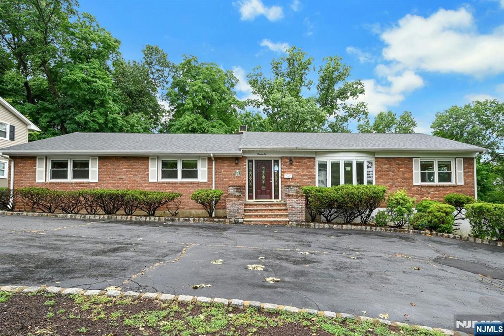 Welcome to this exceptional brick ranch, nestled on a beautifully landscaped .39-acre lot in one of Wayne's most desirable neighborhoods. Offering 3 bedrooms, 3 full bathrooms, public water and sewer, this home seamlessly blends timeless charm with comfortable everyday living. A circular driveway wraps around to the **rear-entry oversized two-car garage**, creating both an impressive arrival and added convenience. Inside, expansive sun-filled living spaces showcase newly refinished hardwood floors, a beautiful fireplace, and an inviting layout designed for both relaxation and entertaining. Sliding glass doors lead to a spacious deck overlooking the private backyard, creating a seamless indoor-outdoor living experience. The finished walk-out lower level is an entertainer's dream, featuring a second fireplace, custom wet bar with granite countertops, built-in refrigerators, custom cabinetry, recessed lighting, a second kitchen, full bathroom, and direct access to the patio ideal for hosting gatherings year-round. Additional highlights include baseboard heat, a new 5-ton central air conditioning system with a transferable 10-year warranty, abundant storage, and quality updates throughout. Packanack Lake membership offers beaches, boating, fishing, and year-round recreation.