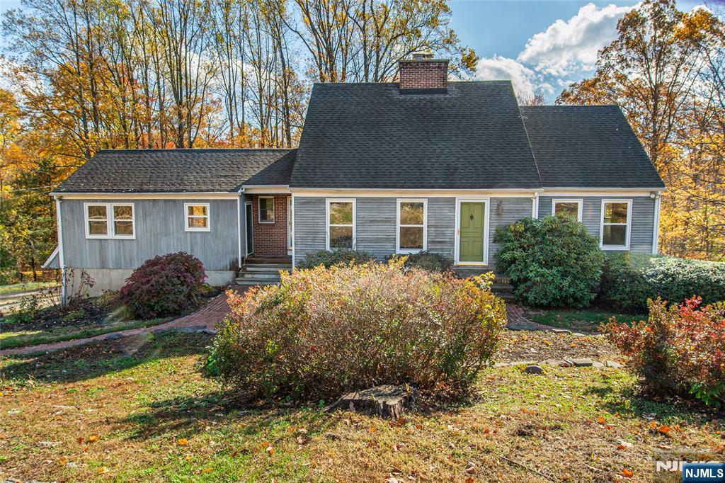 Welcome to this spacious and inviting Custom Colonial Cape located in desirable lower West Milford! This impressive 11-room home sits on 1.27 acres of private, wooded property offering both serenity and space. Featuring 3 full bathrooms and 1/2 bath, this home provides comfort and convenience for everyone. Enjoy a bright, oversize kitchen with a generous dining area, perfect for gatherings and everyday living. The expansive great room is filled with natural light, creating a warm and welcoming atmosphere. The first-floor primary suite includes a private bath for added ease. The ground-level basement with outside access is perfect for a guest suite, with its own kitchenette area, bonus room that can be used as a bedroom, living area, and full bath. Large deck provide the perfect setting for outdoor entertaining or quiet relaxation. In addition it offers, laundry room, utility room, natural gas, new Anderson front windows, wood-burning fireplace, hardwood floors, all you could want in this custom home. Complete with a two-car garage and located just minutes from the town center and Route 23, this home truly has it all space, privacy, and convenience! Co