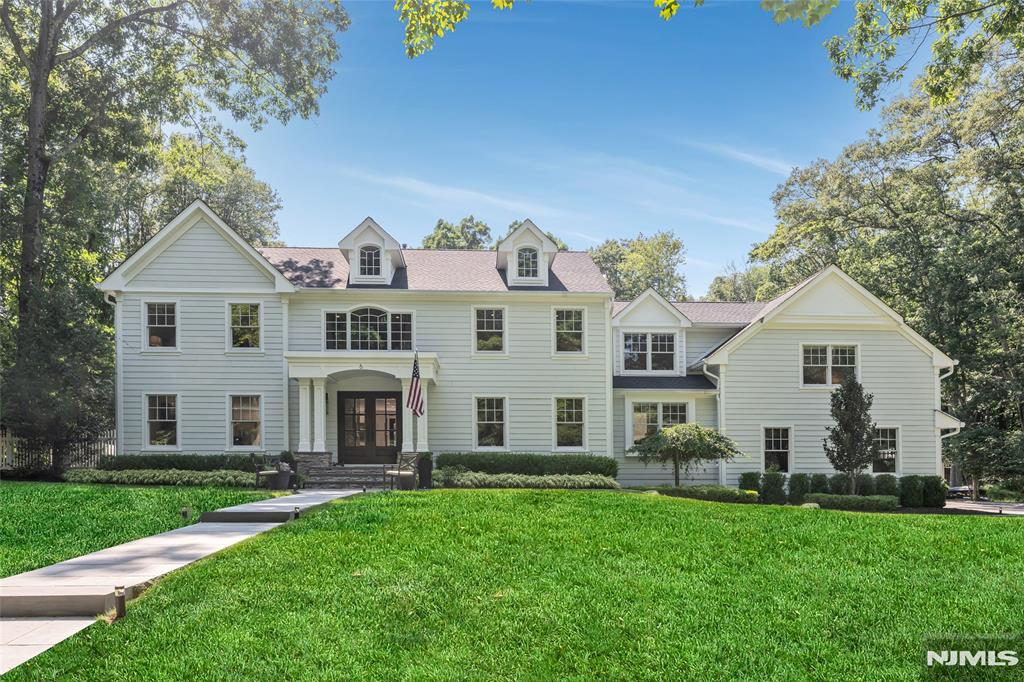 Making an unforgettable first impression on over 1.7 private acres within Allendale's coveted San Jacinto Estates, this exceptional custom home offers a lifestyle rarely found in Bergen County where peaceful, park-like surroundings, complete privacy, and a welcoming community come together in one extraordinary setting. Just minutes from top-rated schools, Crestwood Lake, charming downtown shops and restaurants, and convenient NYC transportation, the location is as remarkable as the home itself. Thoughtfully expanded and beautifully renovated, the sun-filled interior showcases soaring ceilings, expansive living spaces, and a seamless flow throughout. The spectacular chef's kitchen with dual islands opens to a breathtaking great room with a fireplace and dramatic 18-foot sliding doors, while elegant formal living and dining rooms, a private office, and thoughtfully designed supporting spaces provide exceptional everyday functionality. Upstairs, five spacious bedrooms include a luxurious primary suite with a custom walk-in closet and a spa-inspired bath. The finished lower level offers a recreation room, game room, fitness room, and direct outdoor access. Outside, a sprawling patio overlooks lush, park-like grounds complete with a raised koi pond, hot tub, and mature privacy plantings, creating an extraordinary setting for both everyday living and unforgettable entertaining.