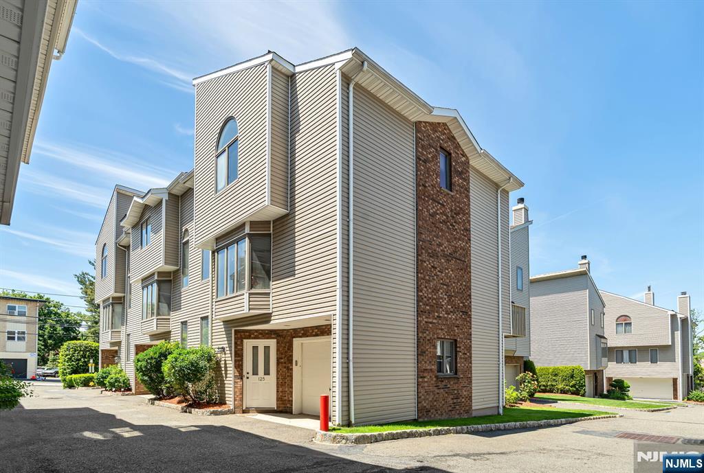 Looking for a 3-bedroom, 2.5-bathroom corner townhome with a garage in Palisades Park, NJ? This one. Three-bedroom, two-and-a-half-bathroom, 1,730-square-foot corner townhome in Palisades Park, New Jersey, Bergen County. Single-car garage with electric opener and interior access. Low HOA fee of $200 in a self-managed community with no special assessments. Ground level features a coat closet, tiled entry foyer, and a rear bedroom with two closets and its own thermostat -- usable as a bedroom, guest room, or home office. The main living level offers an L-shaped living and dining room with hardwood floors, high ceilings, a wood-burning fireplace, and an east-facing bay window. The kitchen includes a gas range, ceramic tile floors, ceramic backsplash, double sinks, stainless steel appliances, and a microwave/convection oven over the range. Full-size side-by-side washer and dryer in a dedicated laundry room. West-facing wood deck overlooks a landscaped common lawn. Central air with Nest thermostat. Gas baseboard heat. Recessed lighting. Corner unit with windows on two exposures. Primary suite features high ceilings, a large walk-in closet, and a full bath with double sinks, a standalone shower, a jacuzzi tub, a skylight, and a linen closet. Second full bath with tub and linen closet. Powder room off the living room. NJ Transit Bus Route 166 to Port Authority Bus Terminal stops on Grand Avenue. Quick access to the George Washington Bridge, Route 9W, and Route 46. Palisades Park.