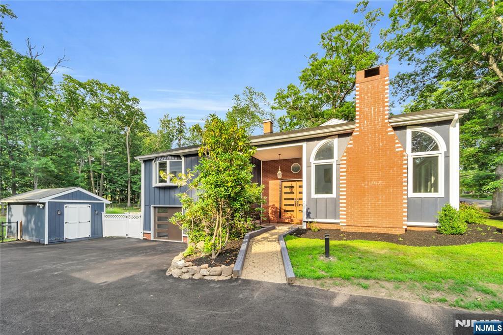 Welcome to this beautifully expanded ranch in desirable Old Tappan, offering spacious living, high-end finishes, and a resort-style backyard. The bright eat-in kitchen is designed for both everyday living and entertaining, featuring new ZLINE appliances, a 60-inch refrigerator, four ovens, two dishwashers, and two sinks. The kitchen flows seamlessly into a banquet-sized dining room, while the inviting living room showcases a dramatic floor-to-ceiling fireplace and oversized windows. Custom Brazilian hardwood flooring and beautifully renovated designer bathrooms enhance the home throughout. The main level features a spacious primary suite with a private bath and generous closet space, plus three additional bedrooms, including a second en-suite, and an additional full bath. The expansive walk-out lower level offers a large family/recreation room, full bath, laundry area, and abundant storage. Professionally landscaped, the fenced backyard is an entertainer's dream with a sparkling in-ground pool complete with a waterfall, a full outdoor kitchen, and multiple areas for relaxing and entertaining. Completing the home are a two-car attached garage equipped with a 220V electric vehicle charger and an extended driveway. A rare opportunity to enjoy luxury indoor-outdoor living in Old Tappan with the added benefit of lower taxes.