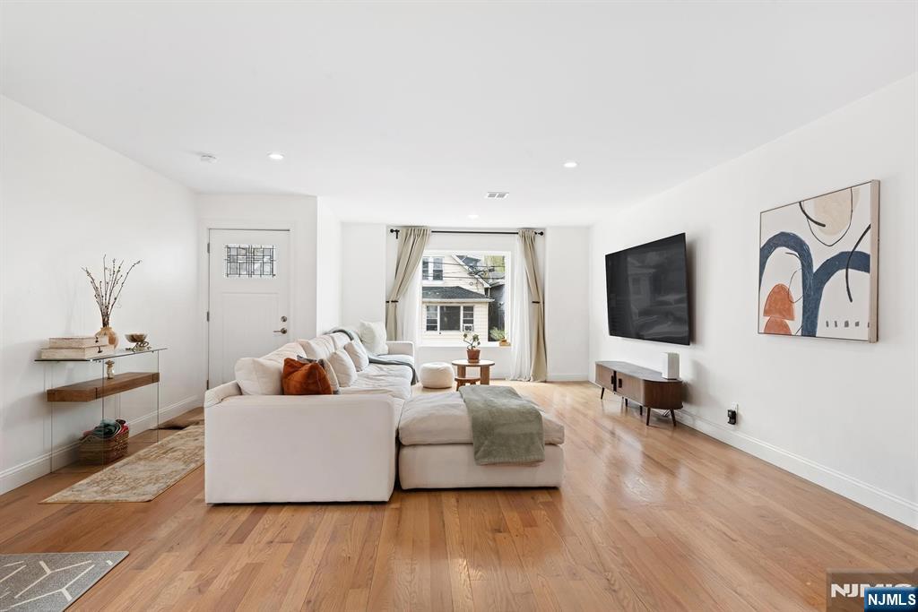 Appointed smart home blending luxury, convenience, and modern design. Newly constructed in 2022, this residence offers contemporary comfort throughout, paired with a low tax structure and long-term appreciation potential. Spanning approximately 2,762 square feet across three thoughtfully designed levels, the home delivers exceptional sense of space, light, and functionality. Rare 9-foot ceilings on both the second and third floors create an airy, open atmosphere, while dual north and south exposures fill the interiors with natural light. The main living level is tailored for modern living, featuring a generously sized living room that seamlessly flows into an expansive kitchen and dining area, perfect for everyday living and entertaining. The upper level features four spacious bedrooms, including a large primary suite, offering privacy and separation from the main gathering spaces. A full walkout lower level adds versatility with a recreation area, laundry room, and direct access to the two-car garage, ideal for a home gym, media room, or additional living space. Situated on a quiet dead-end street with minimal traffic, the home offers a peaceful residential setting while remaining convenient. The Tonnelle Light Rail Station is minutes away, and a NYC bus stop is located one block from the property. Close to shopping, dining, and everyday essentials, this home presents a rare opportunity to enjoy space, comfort, accessibility, and modern living in one exceptional residence.