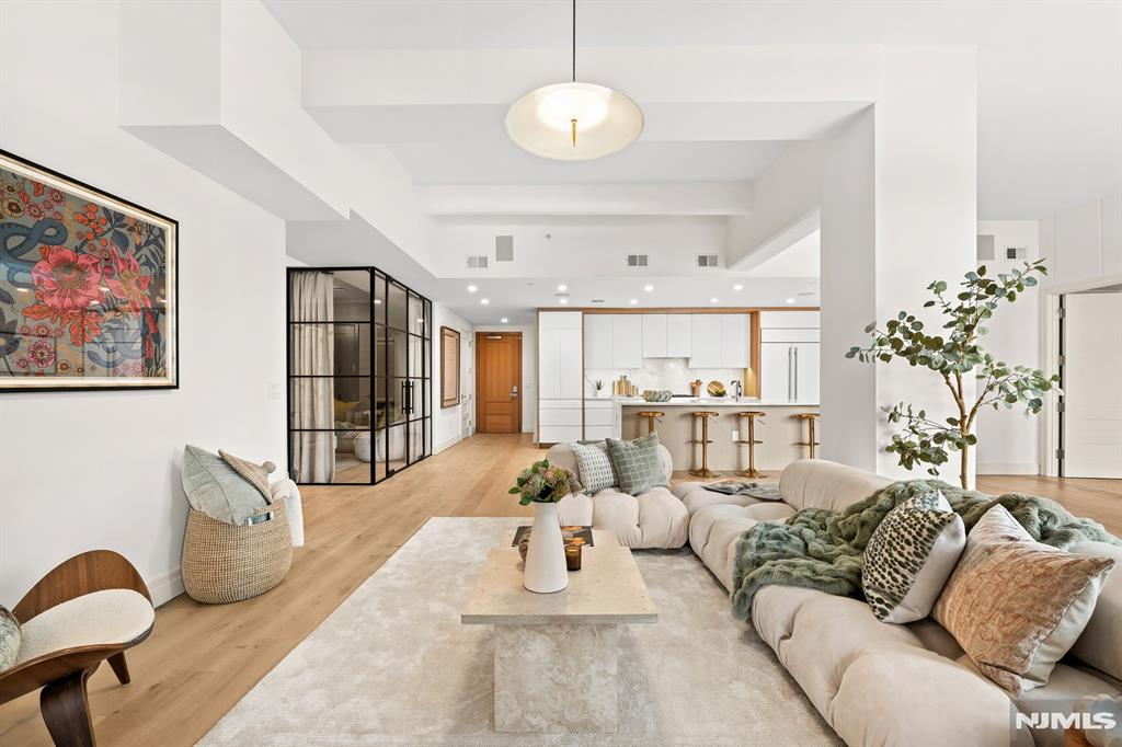 A rare offering at the iconic Wonder Lofts, this expansive 2,456 sq ft, 3-bedroom + den, 3.5-bath home blends authentic loft character with elevated, designer finishes. Reimagined by Joan Enger of J. Patryce Design Co., Residence 508 showcases exposed brick, steel beams, and concrete columns paired with refined, custom interiors. A thoughtfully designed entry features a built-in mudroom, leading to an open-concept living and dining area ideal for modern living. The chefs kitchen is equipped with Calacatta Lava countertops, a waterfall island, custom cabinetry, and premium appliances including Sub-Zero, Wolf, and Bosch. A versatile, enclosed alcove with glass-and-steel detailing serves as a perfect office, family room, or guest suite with its own bath. The primary suite offers a custom walk-in closet and spa-like bath with Italian marble, soaking tub, and glass shower. Two additional bedrooms are spacious with beautifully finished baths. Additional highlights include custom millwork, European oak floors, smart home features, Sonos sound, in-unit laundry, and a 212 sq ft private terrace. Includes deeded parking and storage. Residents enjoy 14,000+ sq ft of amenities, including a rooftop pool, fitness center, and lounge. Near Manhattan via ferry, PATH, and NJ Transit.