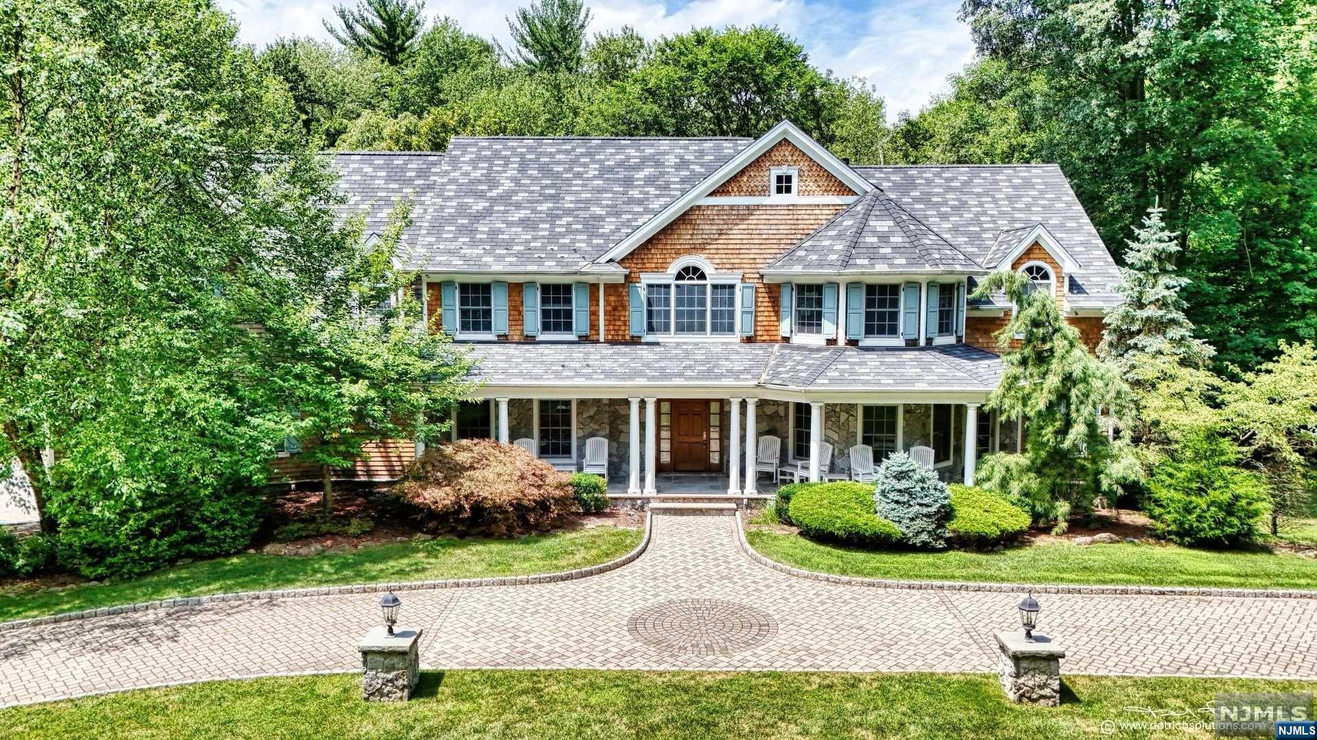 Classic Saddle River estate w/ bright eastern exposure on 2 acre private, wooded property with a semi-circular paver dw. Located on a desirable double cul-de-sac in the heart of town. Grand 2 sty EF opens into the 2 sty GR w/ FPL. This room is sun filled with large glass doors opening up to the back deck overlooking the lush ppty. Formal LR, formal DR, office. The gourmet chef's kitch. with dining alc. opens to the deck. 1st fl BR ensuite with a den w/ FPL offers privacy and versatility. 2nd fl primary suite boasts double walk-in closets w/ sitting room w/ FPL. The open balcony leads to 4 BR and 4 FB. The walk-out finished lower level opens up to a blue stone patio and outdoor kitchen. Inside, a fully equip prep kitchen, theater, gym, wine cellar, rec area.This home boasts 2 generators, sec. sys. and 3 oversized garage bays. Meticulously maintained by its original owners since its construction in 2006, this home has enjoyed continuous updates and is move in ready.