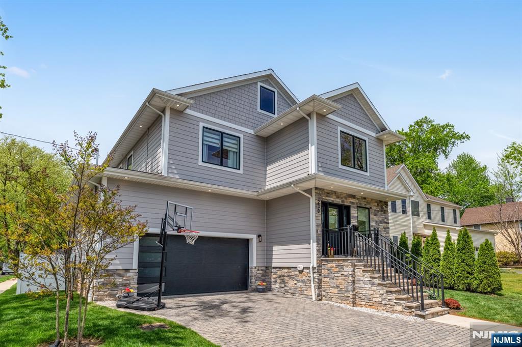 Absolutely stunning newer construction over an existing foundation in Teaneck, offering exceptional curb appeal, a beautifully designed backyard, and high-end finishes throughout. Only a few years young, this thoughtfully designed home features 4 bedrooms, 2 full bathrooms, 2 half bathrooms, an open-concept layout, a 2-car garage, and a fully finished basement. The main level offers seamless flow for both everyday living and entertaining, featuring a formal dining room, powder room, and a gorgeous chefâ€™s kitchen with premium finishes that opens directly to the spacious family room with a fireplace. Sliding glass doors lead to a large deck overlooking the private, manicured backyard oasis, complete with an expansive Trex deck, fully equipped outdoor kitchen, and above-ground pool. Mature landscaping creates a serene setting with an impressive level of privacy. Upstairs, the luxurious primary suite serves as a true retreat, complete with a walk-in closet and a spa-like ensuite bathroom featuring a soaking tub, oversized glass shower, and dual vanity. Three additional generously sized bedrooms share a beautifully appointed full hallway bath, and top-floor laundry adds convenience. Fully finished basement provides excellent bonus space, ideal for a recreation room, home office, or playroom, and also features a brand new powder room. A truly exceptional home offering style, comfort, and functionality in one of Teaneckâ€™s most desirable settings. Donâ€™t miss this opportunity.