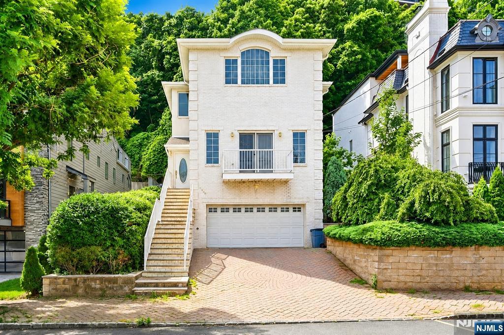 Rarely available custom single-family home in the heart of Edgewater's highly coveted Undercliff neighborhood. This meticulously designed four-bedroom, three-and-a-half-bathroom residence offers nearly 3,000 sq ft of thoughtfully designed multi-level living space. Abundant natural light welcomes you into the entry foyer and leads to a dramatic sunken great room with soaring ceilings and expansive windows that frame breathtaking views of the Hudson River and iconic New York City skyline. Designed for everyday living and entertaining, the main level features a formal dining room that flows into a gourmet kitchen, complete with granite countertops, professional-grade appliances, and an adjoining family room. Enjoy your private patio and yard with fruit trees â€”a special outdoors retreat. Upstairs, the luxurious primary suite showcases spectacular views, two walk-in closets and a spa-inspired bathroom. Three generously sized bedrooms and a full hallway bath complete the upper level. Additional highlights include an attached two-car garage with paver driveway, two bonus rooms ideal for a home office, gym, or storage, multi-zone heating, a new central cooling system, central vacuum, and a dedicated laundry room. Perfect for commuters and lifestyle enthusiasts alike, this exceptional home offers unparalleled access to NYC transportation, the Hudson River Waterfront Walkway, and premier shopping and dining destinations along River Road. Love where you live on New Jersey's Gold Coast