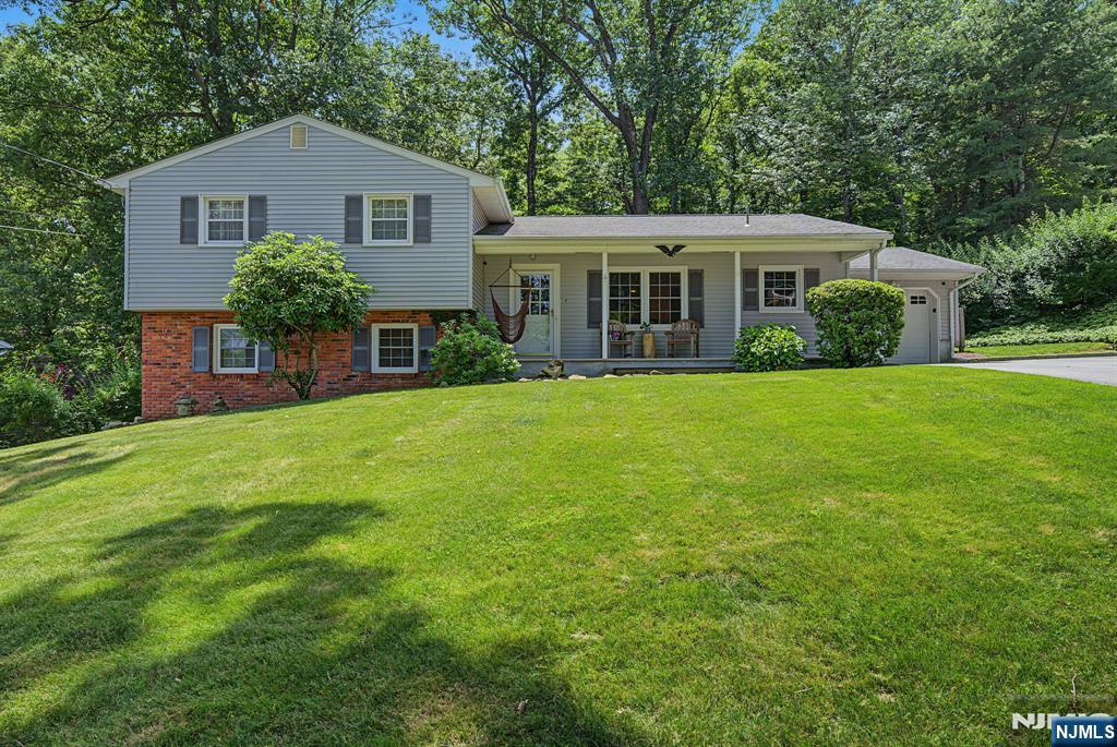 Enjoy this outstanding, meticulously kept expanded split level home with a gorgeous primary suite or in laws addition and all huge rooms on a professionally manicured lot that backs to private woods! First floor primary suite constructed in 1998 features a beautiful, private bath with double sinks, bay windows, a walk in closet and close access to the newly constructed rear deck. This wonderful home is truly in move in condition and features large rooms including a second 20 x 13 bedroom with a custom closet on the second floor. Other features include hardwood floors, an updated kitchen with a breakfast area AND countertop seating that opens to the living room, offering views of the scenic woods beyond the backyard perimeter. The home also has two zone heat, central air, plenty of storage throughout including 2 attics, and a ground level family room. The primary suite can also be easily utilized as a private and peaceful in law suite. Best of all, the home is in beautiful Beacon Hill of Denville Township. A MUST SEE!